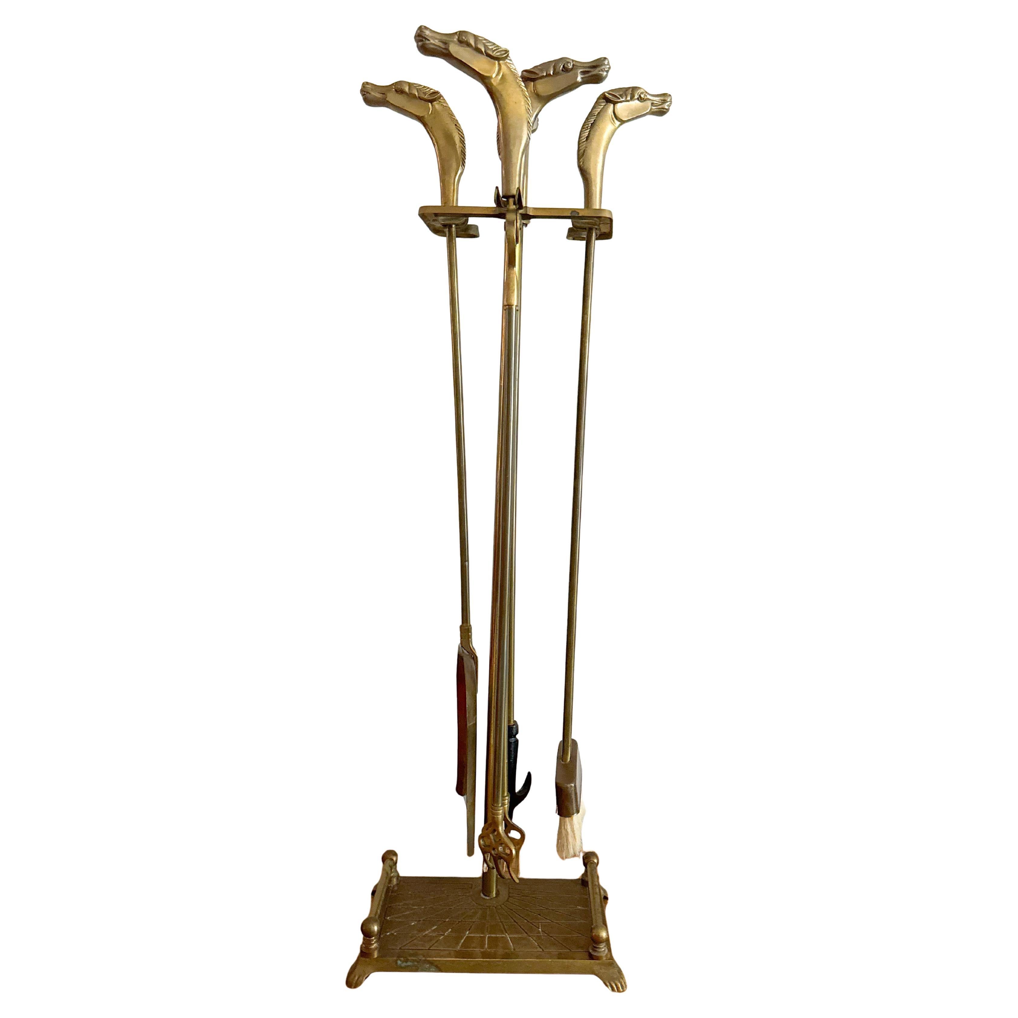 Elegante juego de utensilios para chimenea de latón macizo de estilo Maison Jansen, con esculturales mangos de cabeza de caballo. Este diseño con motivos ecuestres, de mediados del siglo XX, incluye cuatro herramientas -pala, atizador, cepillo y