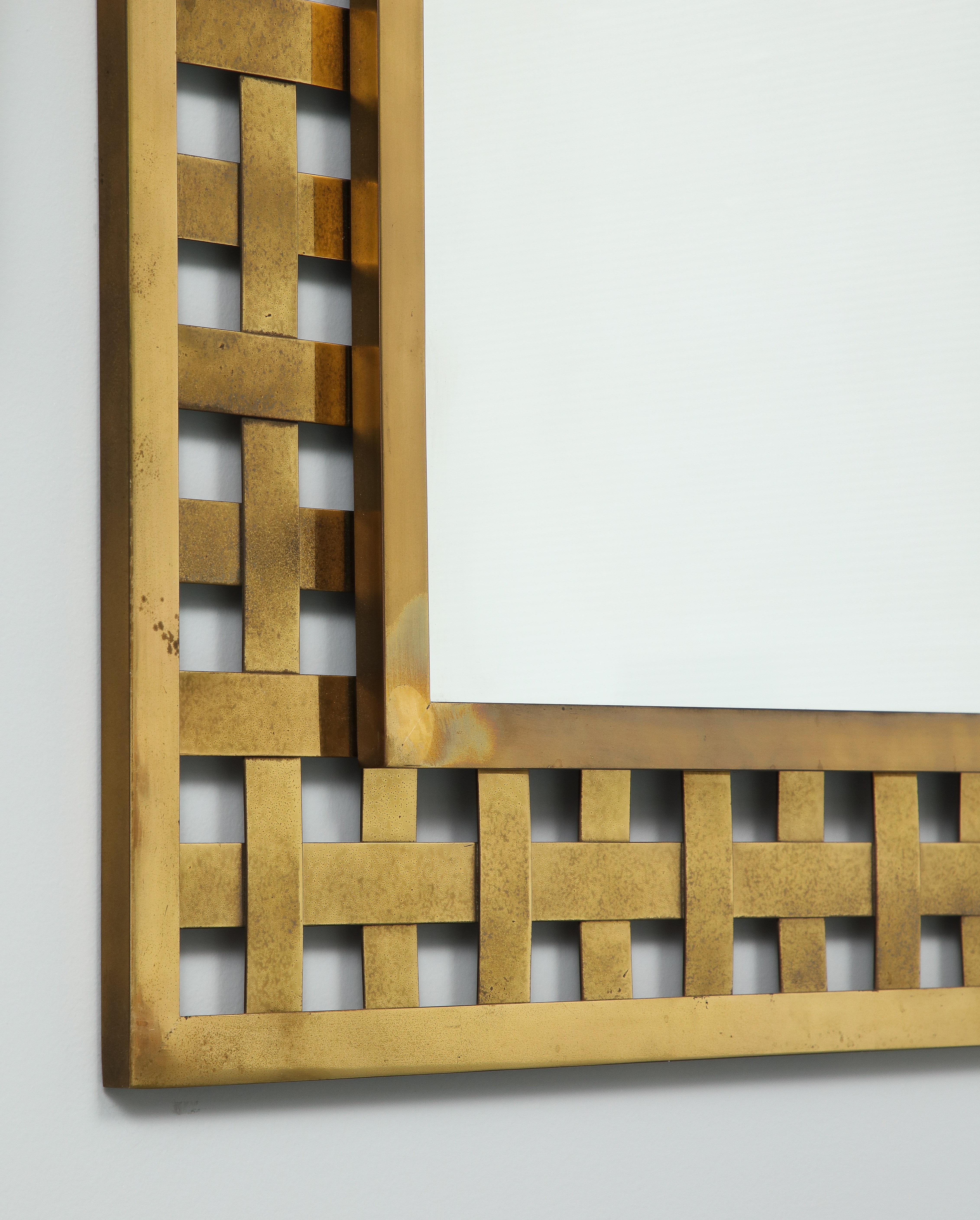The mirror is rectangular and the brass lattice pattern gives a sophistication to the design. 