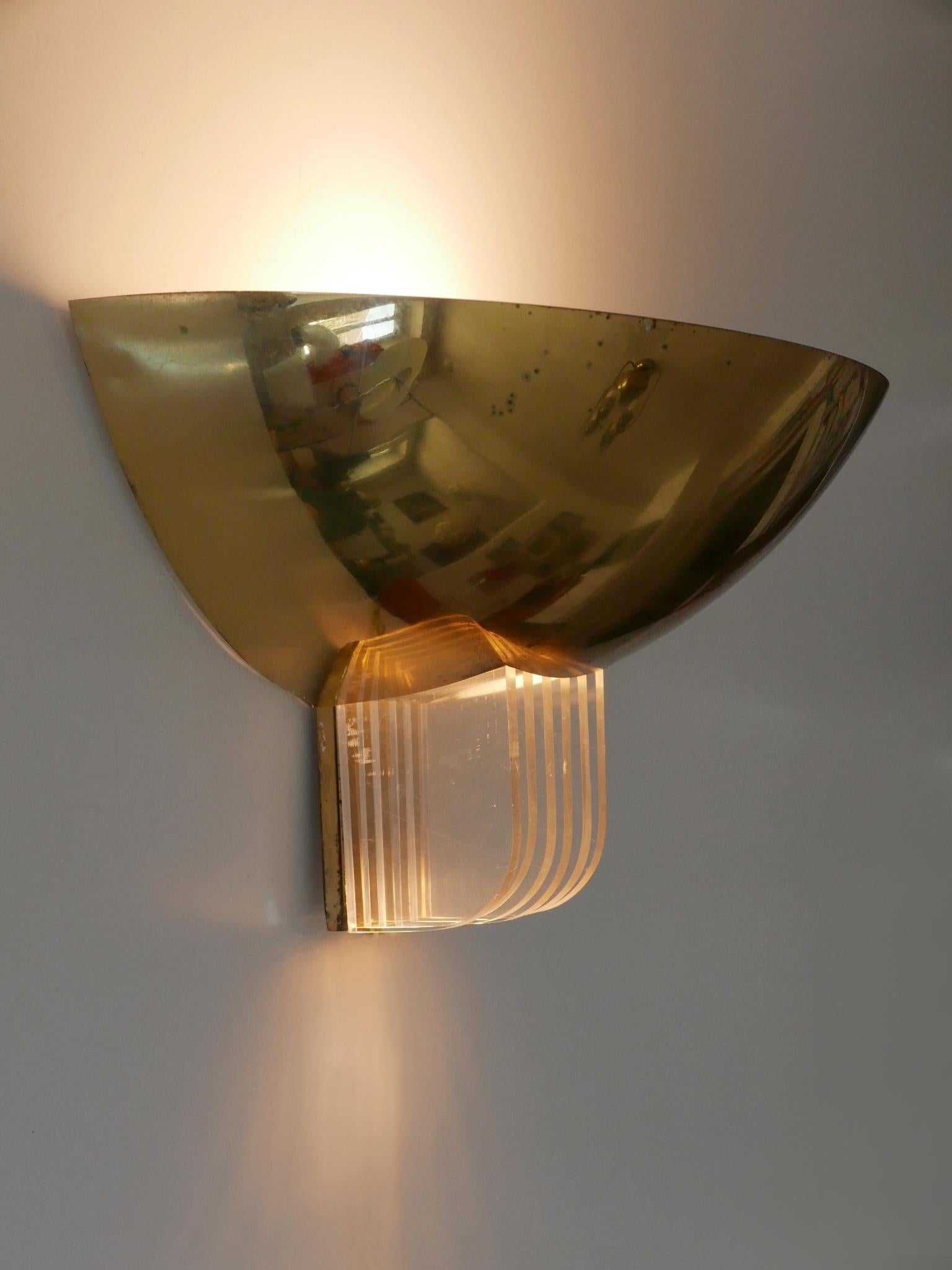 Rare and elegant Mid-Century Modern sconce in classical art deco design. Designed and manufactured probably by Vereinigte Werkstätten, Germany, 1960s.

Executed in brass, lucite and metal, the sconce comes with 1 x E27 / E26 Edison screw fit bulb