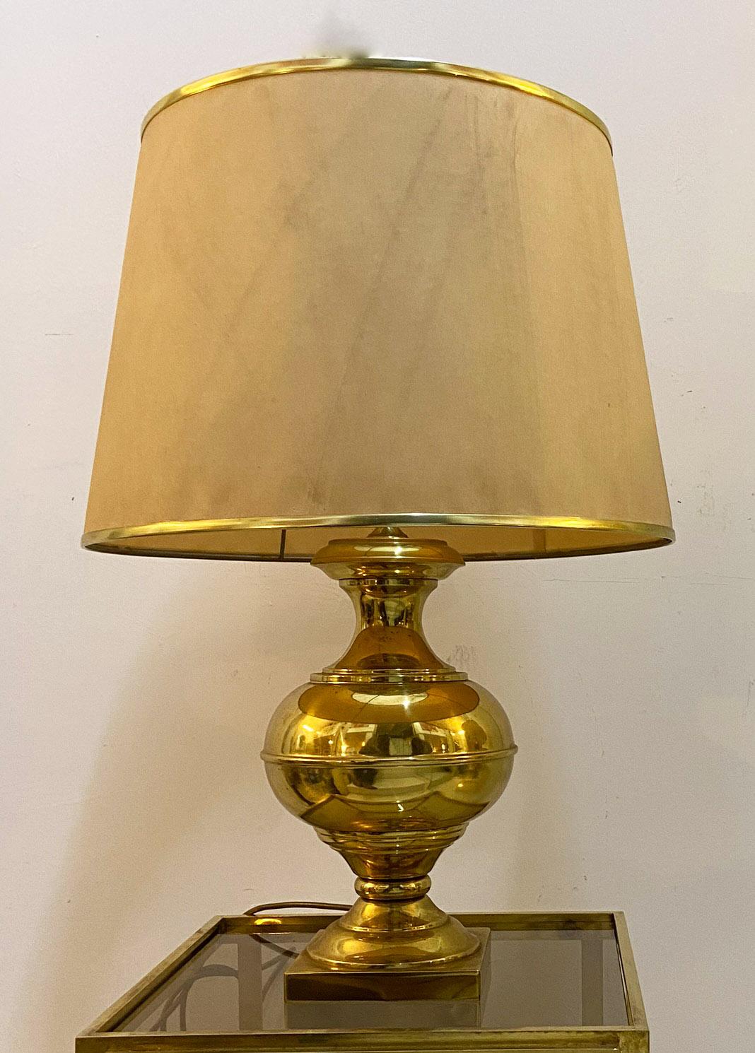 Elegant brass table lamp with polished finish, Italian production of the 1960s. Fabric lampshade with brass edges.