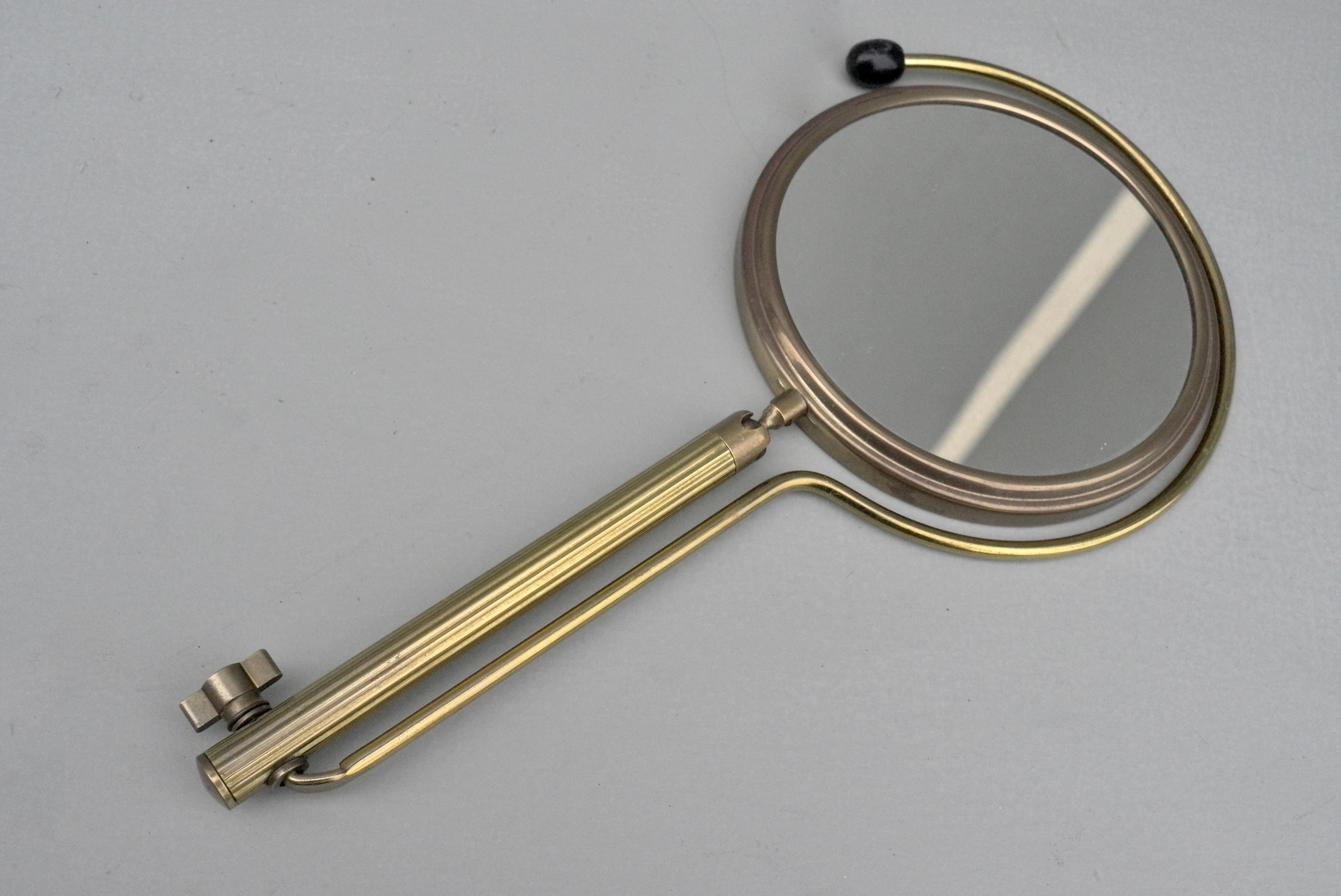 Brass table make up vanity mirror, France 1950s. You can put it on a table, vanity or wall and you can hang it around your neck to do your make up. The mirror has two sides, a magnifier on one side and normal on the other.