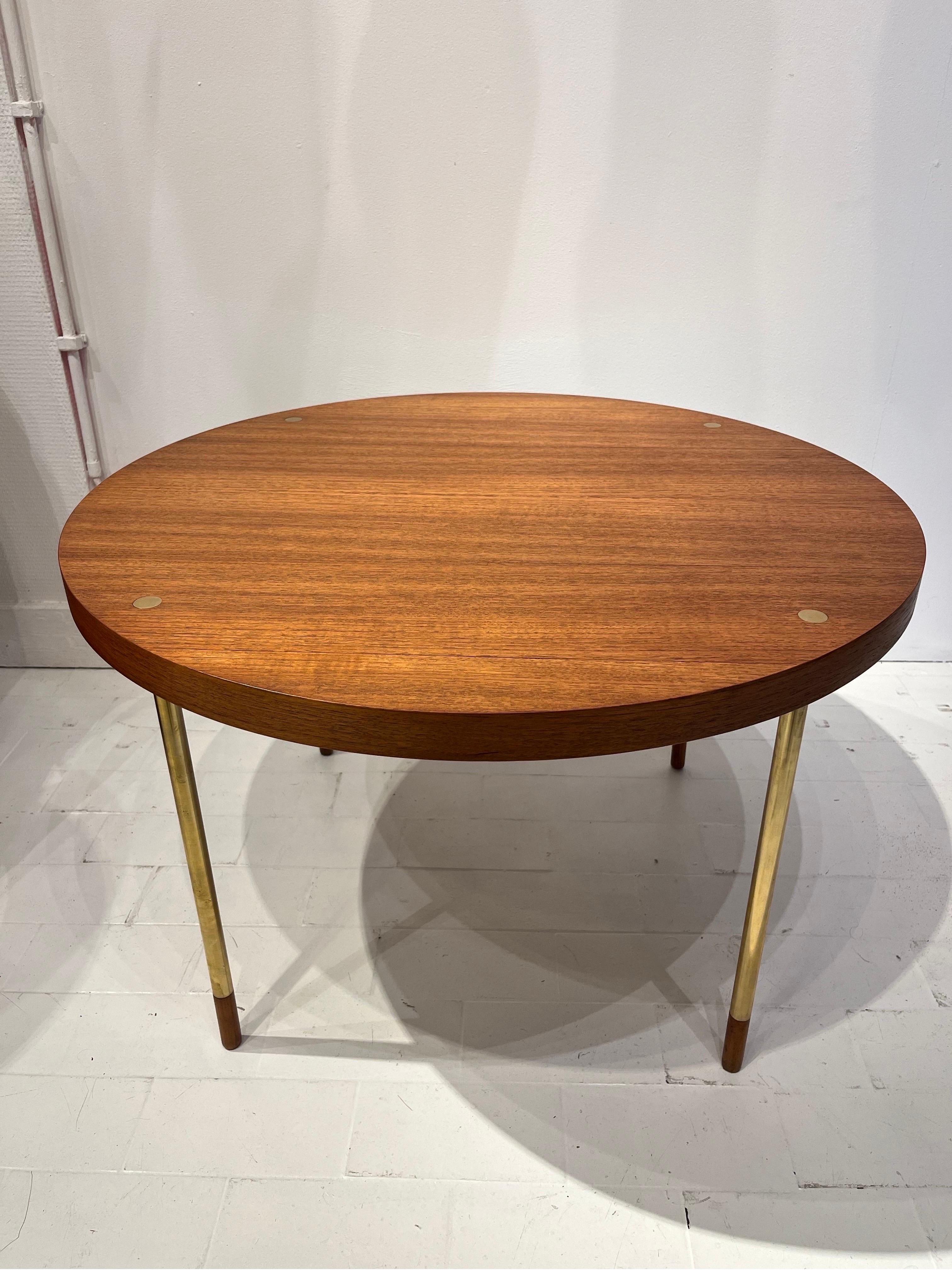 The present table is made of brass and Italian walnut veneer. The design is reminiscent of works by Ettore Sottsass who used this principle of incrusted feet into top. The contrast between the wood and the brass creates a well achieved decorative