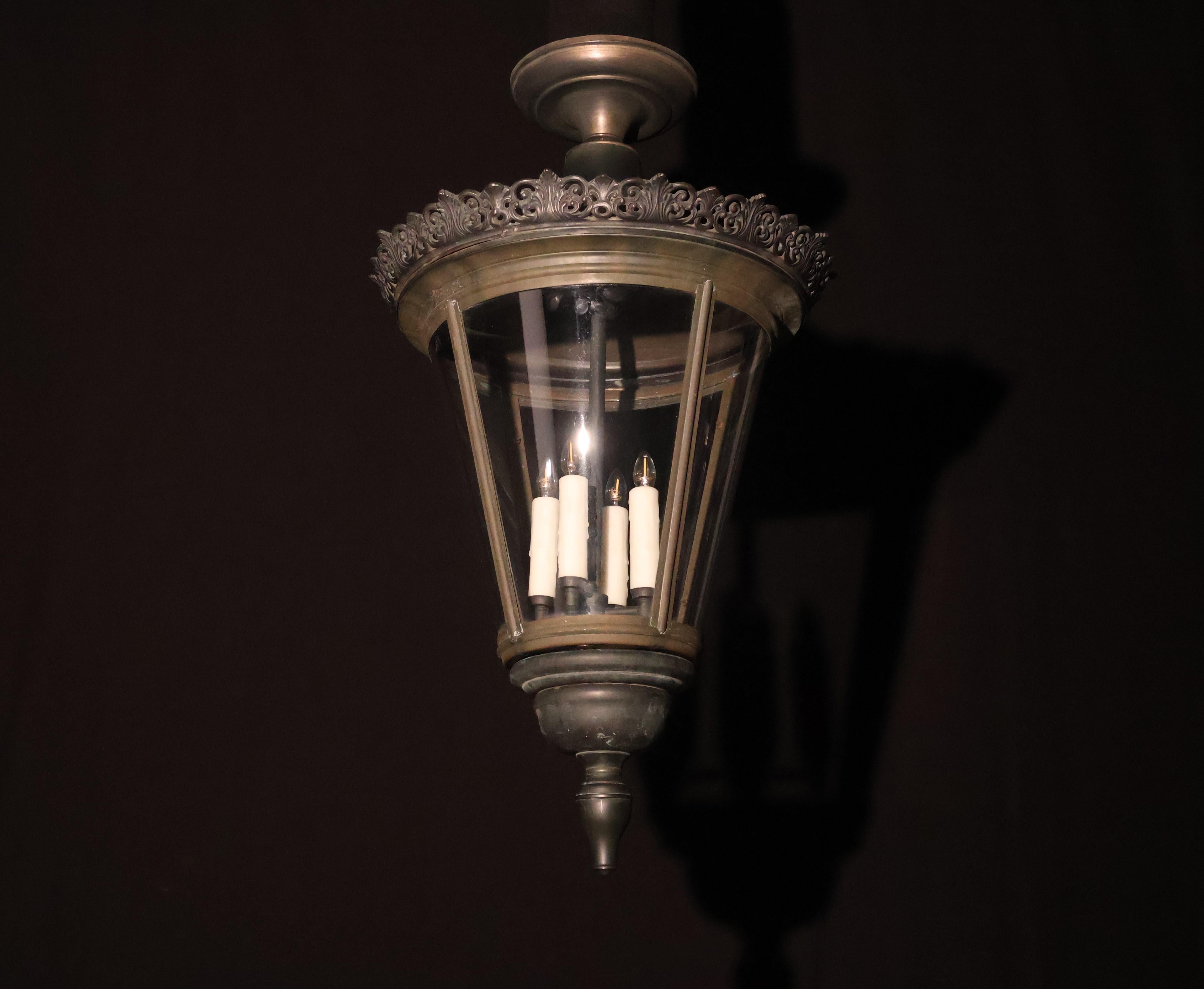 Fina y elegante linterna de bronce de forma cónica, con una elegante galería perforada en la parte superior. Paneles originales de cristal curvado. Pareja disponible.
Francia, hacia 1940. 4 luces
Dimensiones: Altura 33  Diámetro  19