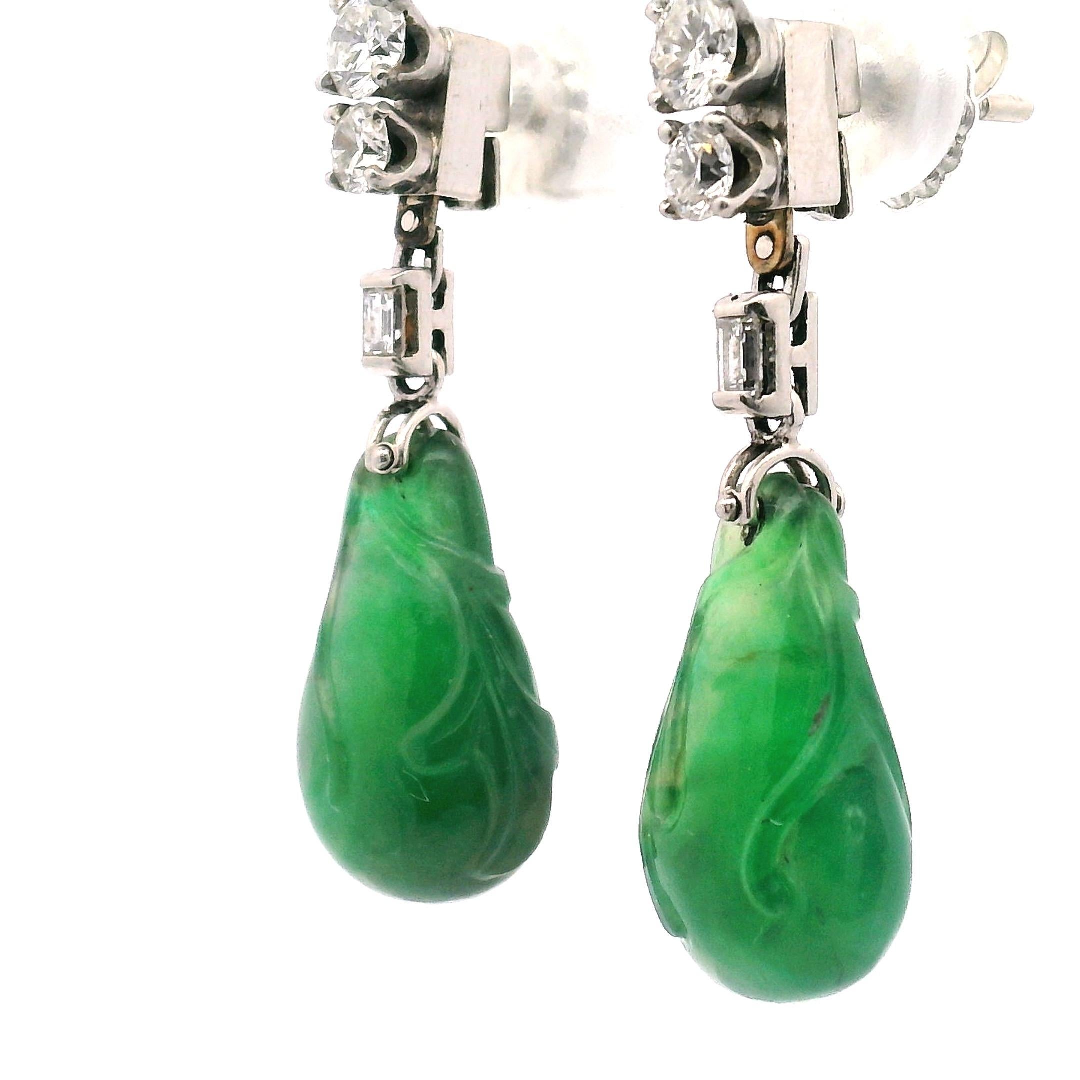 Tachuelas de diamantes redondos en duelo con un puente de diamantes talla baguette, Con una piedra translúcida tallada en forma de pera de color verde jade.

Compuesto por:

Dos piedras de jadeíta (Sin Tinte) 

Cuatro diamantes talla redonda y dos