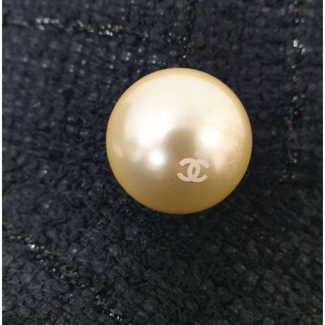 Esci con stile con questo splendido cappello di Chanel in tweed nero! Questo pezzo unico presenta squisiti dettagli di perle che aggiungono un tocco di lusso e raffinatezza a qualsiasi abbigliamento. Perfetto per completare un look classico e chic,