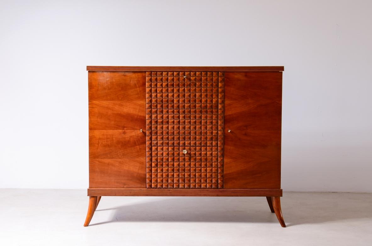 
COD-2724
Paolo Buffa (1903-1970)

Elegant cherry cabinet with diamond-cut wood front, sabre-shaped feet, two side doors and two drop-down shelves with a bar covered in ground glass. Glass holder shelves with wave decoration.

Manufactured by Mario