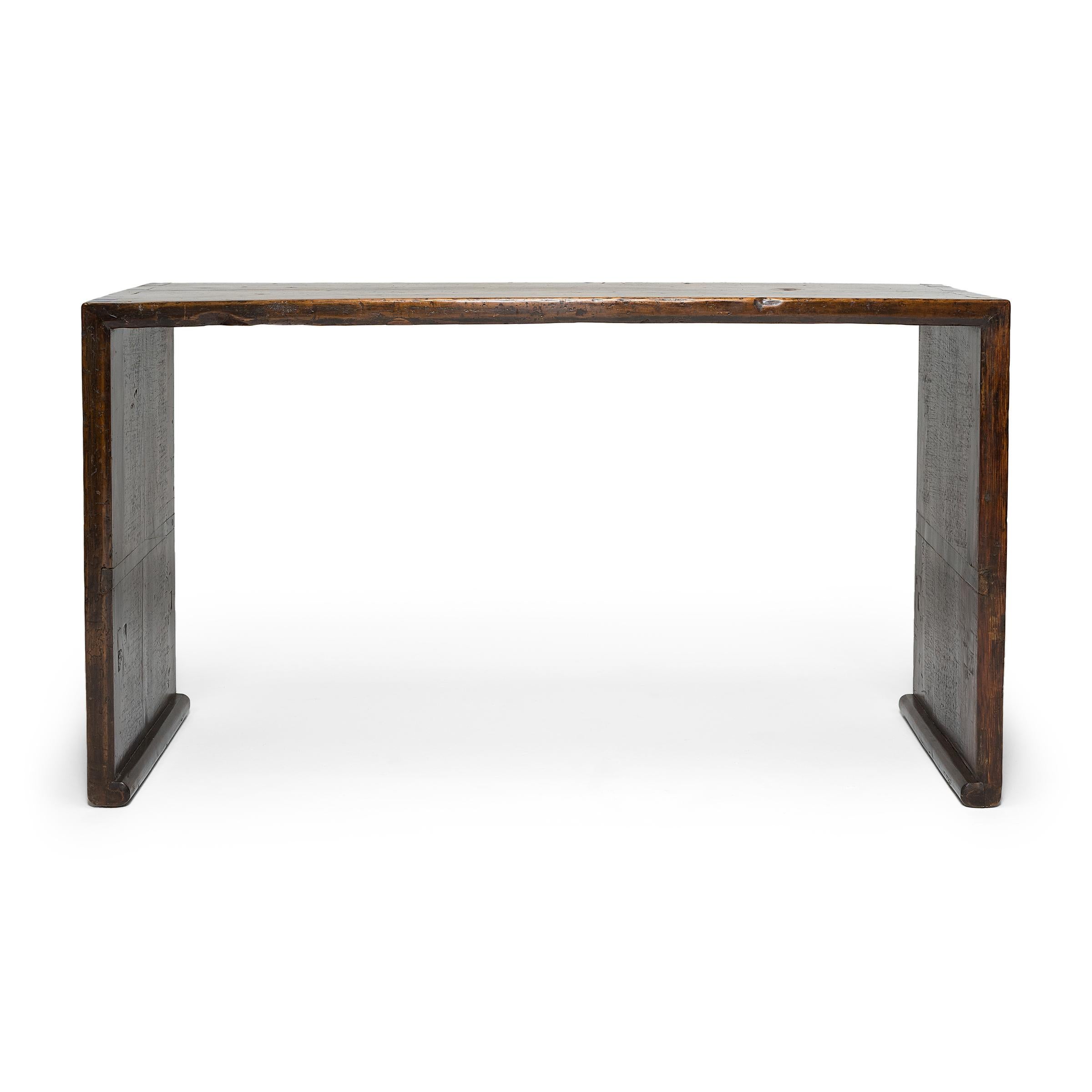 With no stretchers or spandrels, this gorgeous altar table flows like a ribbon, rounding the bend to form straight, waterfall sides that end in scrolled feet. Dated to the mid-19th century, the console is expertly crafted of northern elm (yumu) with