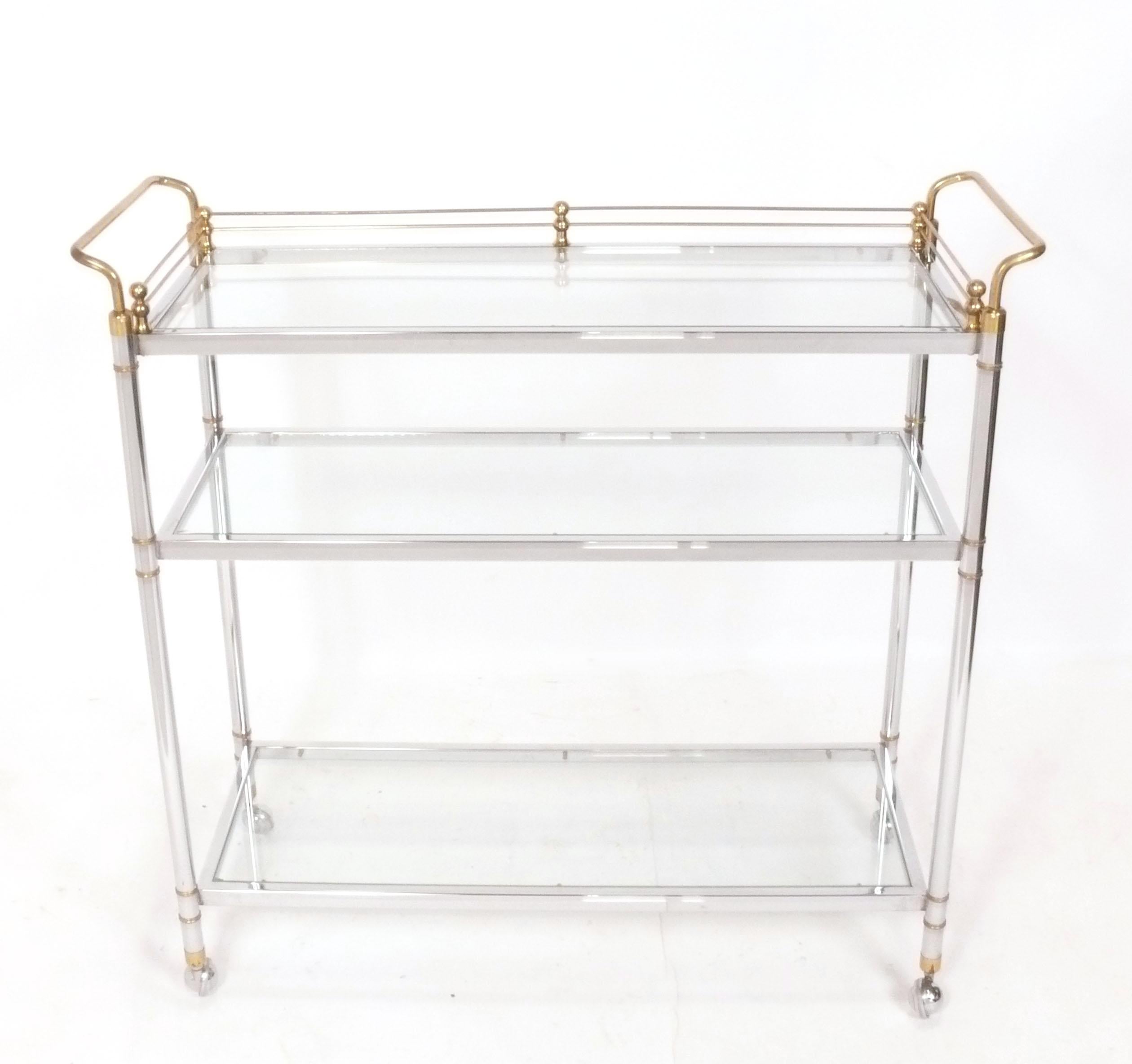 Elegant chariot de bar en chrome et laiton à la manière de la Maison Jansen, français, vers les années 1960. Cette pièce de taille polyvalente peut être utilisée comme chariot de bar ou de service, ou comme rangement roulant dans un bureau.