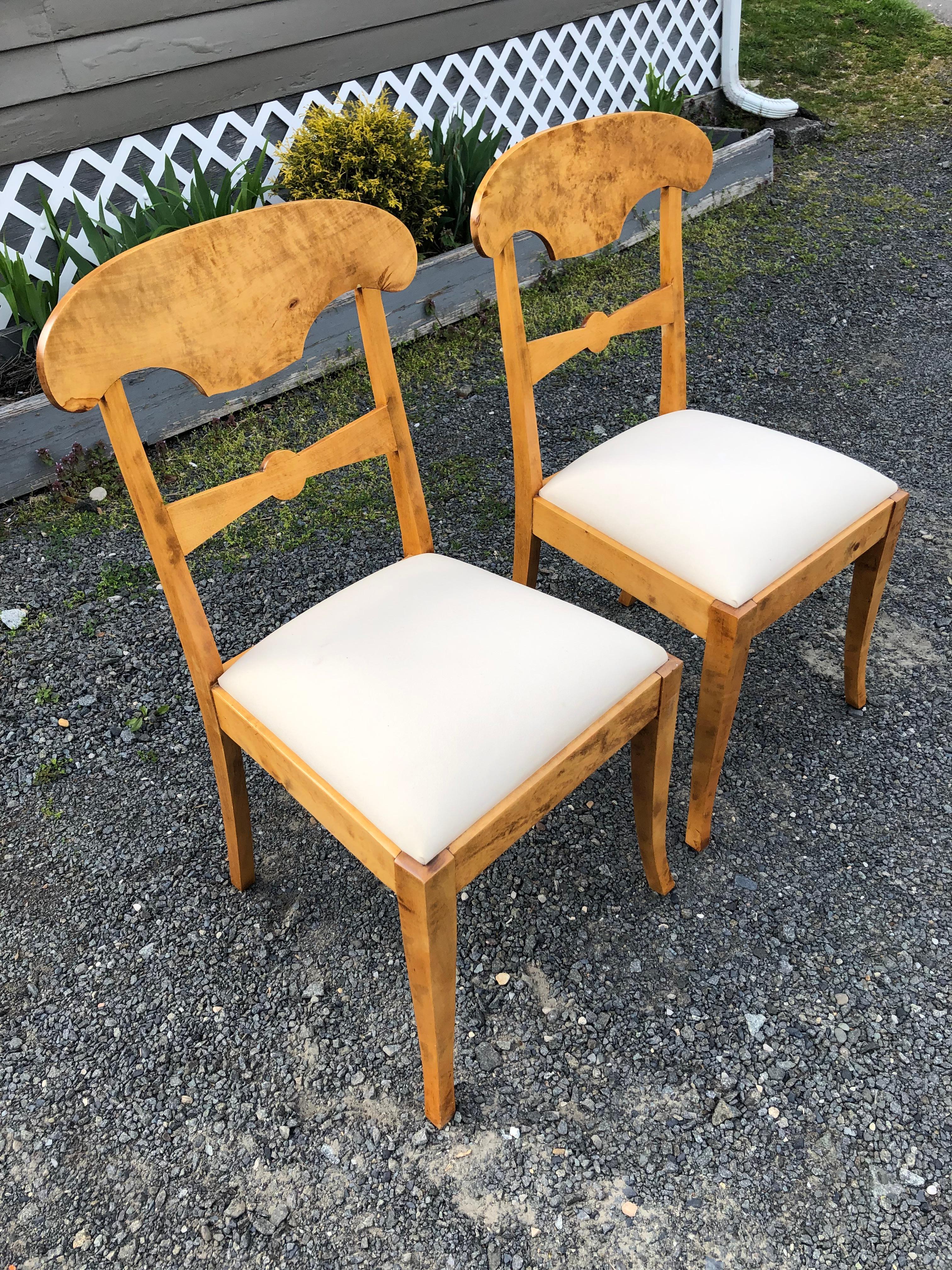 Charmante paire de chaises d'appoint Biedermeier en frêne blond avec des coussins d'assise et de jolis pieds légèrement évasés.