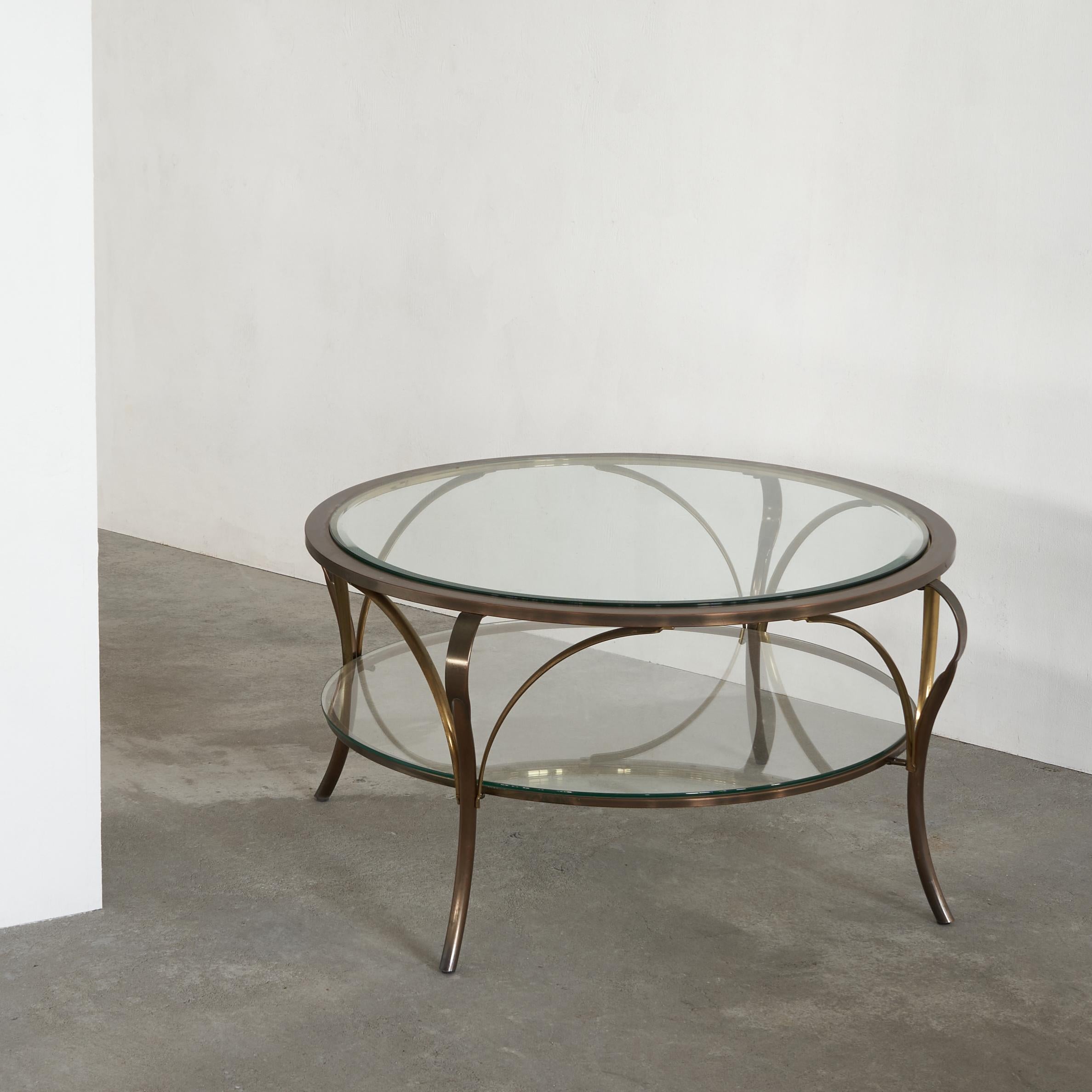 Very elegant coffee table in glass and brass. A classic design with flowing lines, great curves and a wonderful interplay between the different materials.

Due to the glass this is a really airy and subtle coffee table. The two tier design