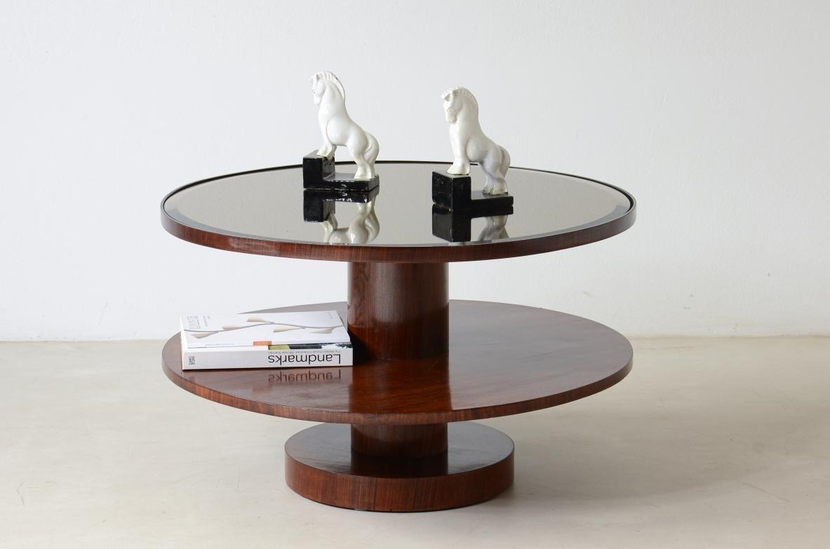
COD-2728
Elegant coffee table with central column and two tops, one in wood and the top in mirrored moulded glass.

Italian manufacture 1930ca.