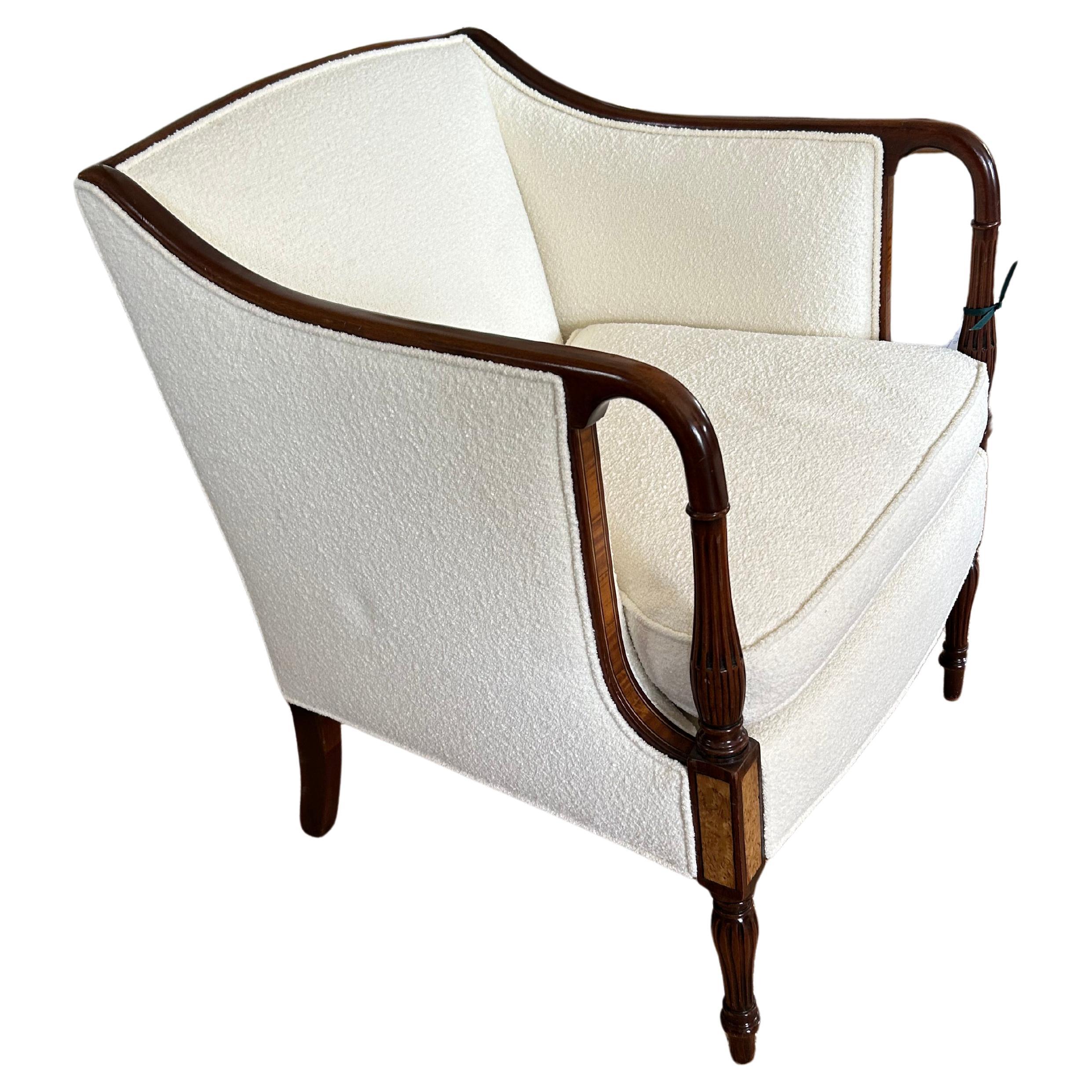 Elegant and especially luxurious antique club chair having glossy mahogany frame with inlay satinwood and handsome turned legs.  New boucle upholstery is top drawer with marshmellow comfy down seat cushion.
Arm height 29
