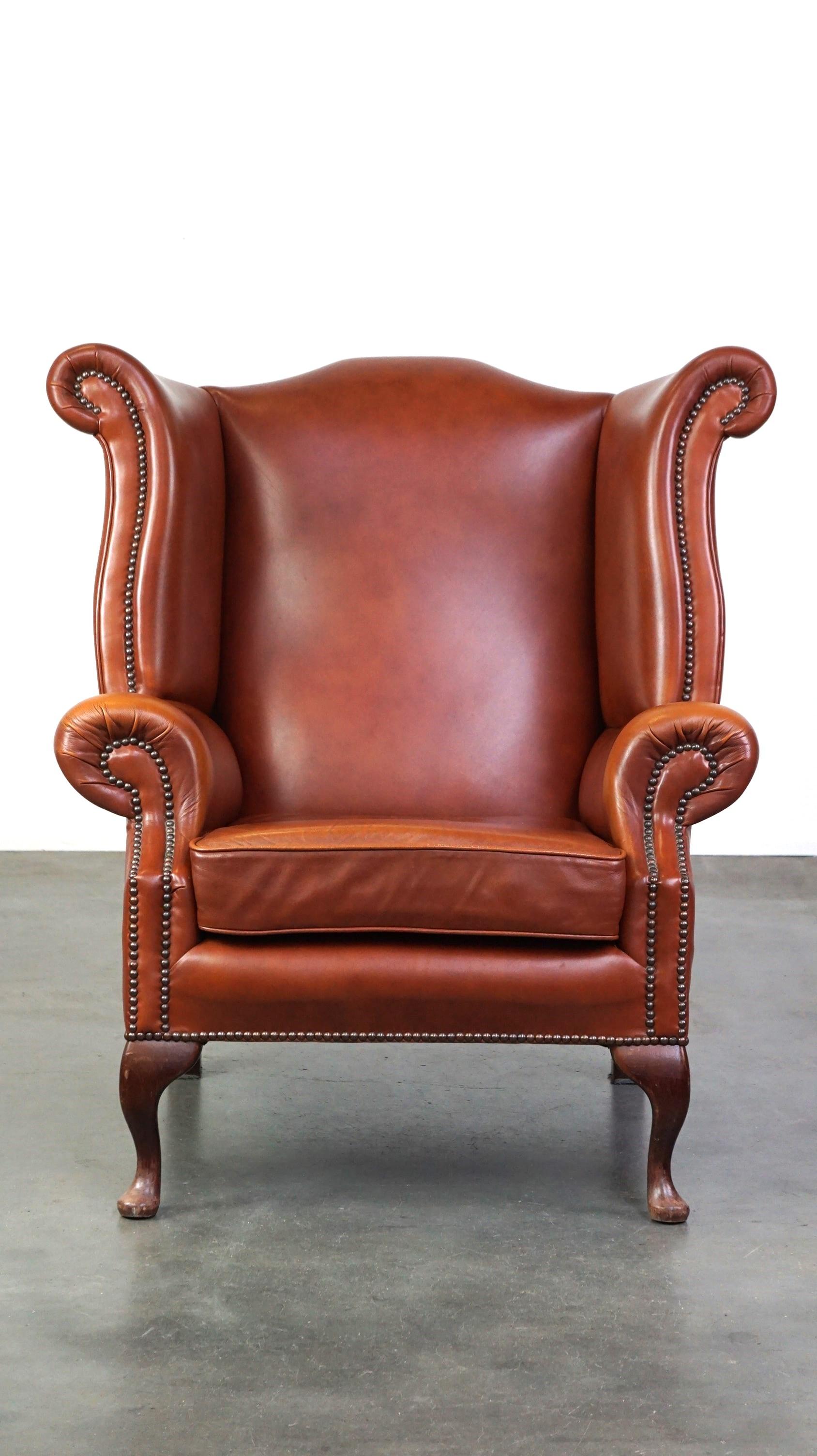 Cet élégant fauteuil à oreilles en cuir de vachette offre une expérience d'assise merveilleusement confortable et détendue. Il est doté d'un coussin d'assise amovible fixé à l'aide d'une bande velcro, ce qui lui permet de rester parfaitement en