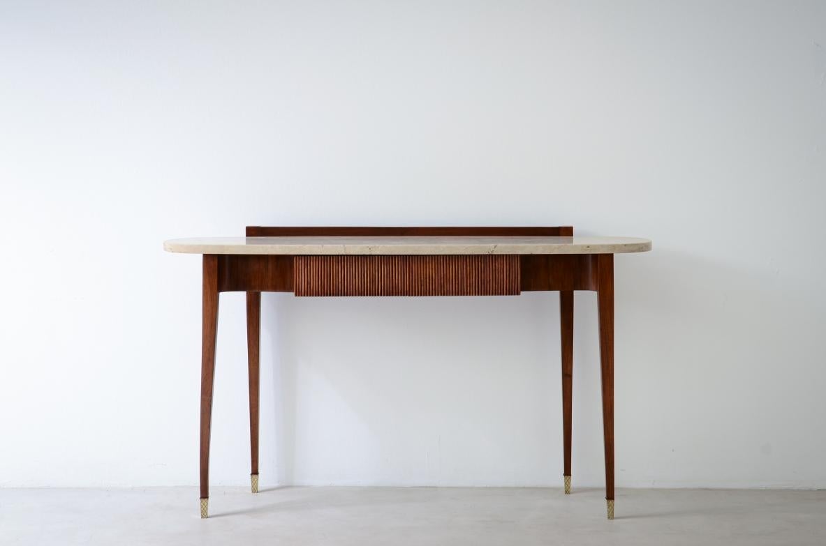 OD-2604
Elegant console moved on the front and sides, with two ribbed wooden drawers and oval travertine top, brass crown tips.

Italian manufacture, early 1950s.