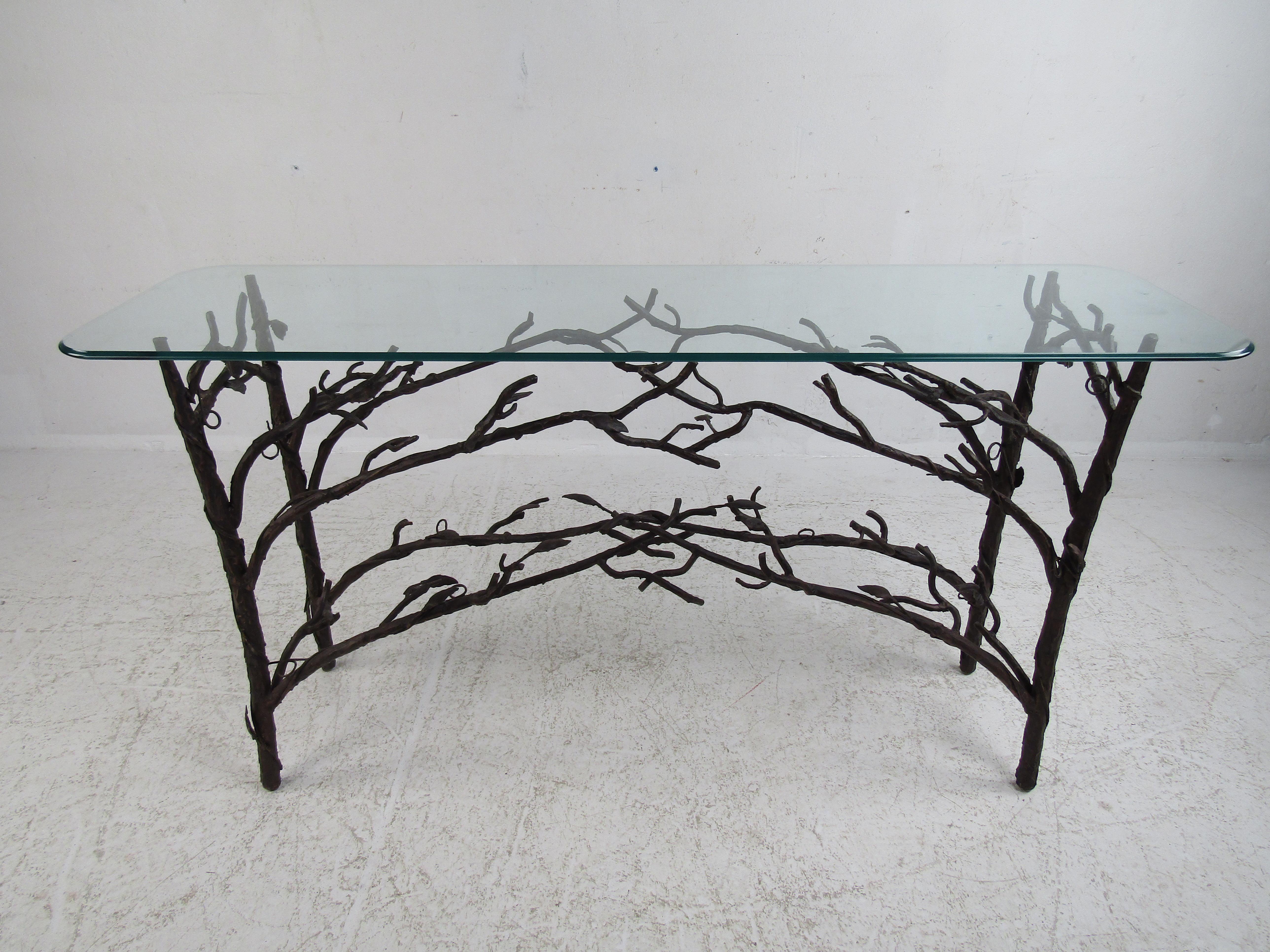 This stunning Diego Giacometti style hall table boasts a wild metal base shaped like trees with branches. A design that perfectly complements any home, business, or office. A glass top with a unique shape sits comfortably on top, perfect for