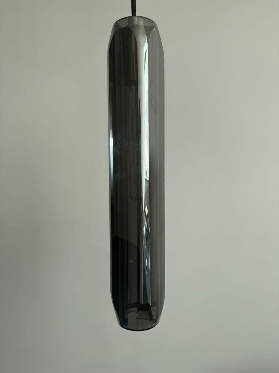 Esta impresionante y elegante lámpara colgante Selene está fabricada a mano a partir de un bloque macizo de cristal de plomo de color gris acero, tallado y pulido a mano para conseguir una bella forma que refracta la luz con gran efecto

El Colgante