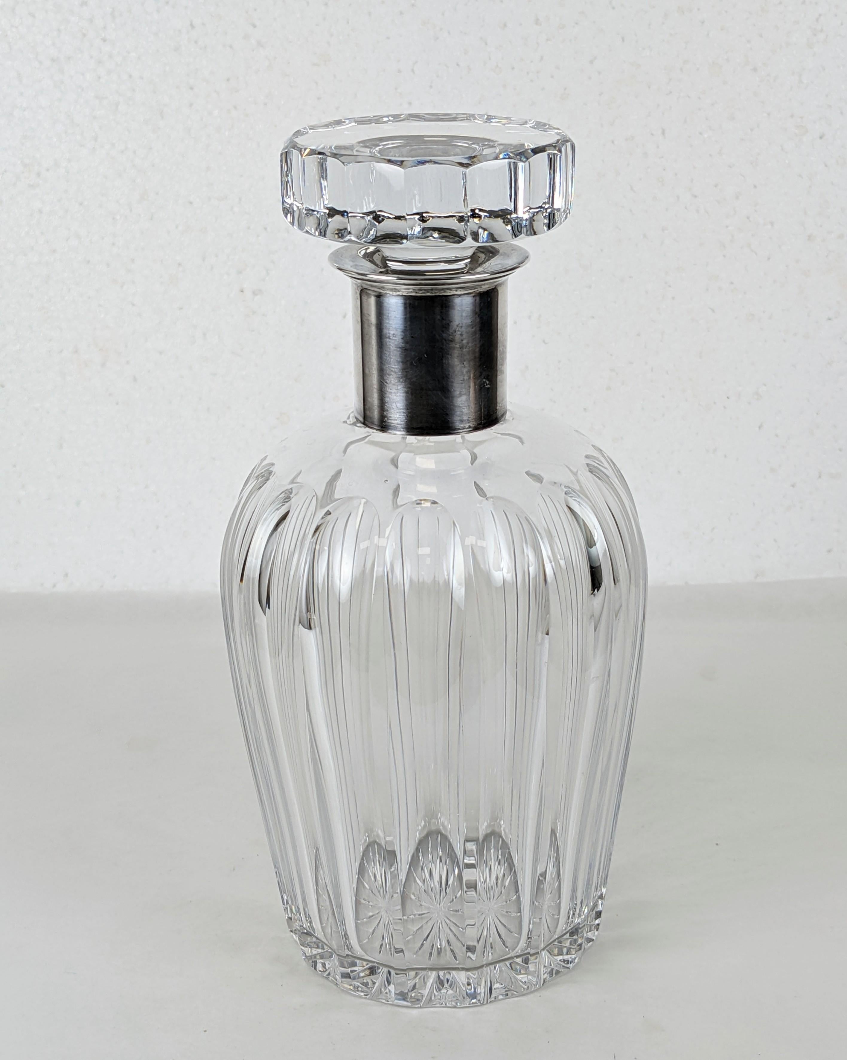 Elegant Crystal and Sterling Decanter by Mauser from the 1950's. Deco style fluted lines with matching stopper anchored by sterling mount. 
Measures: Heavy quality. 8