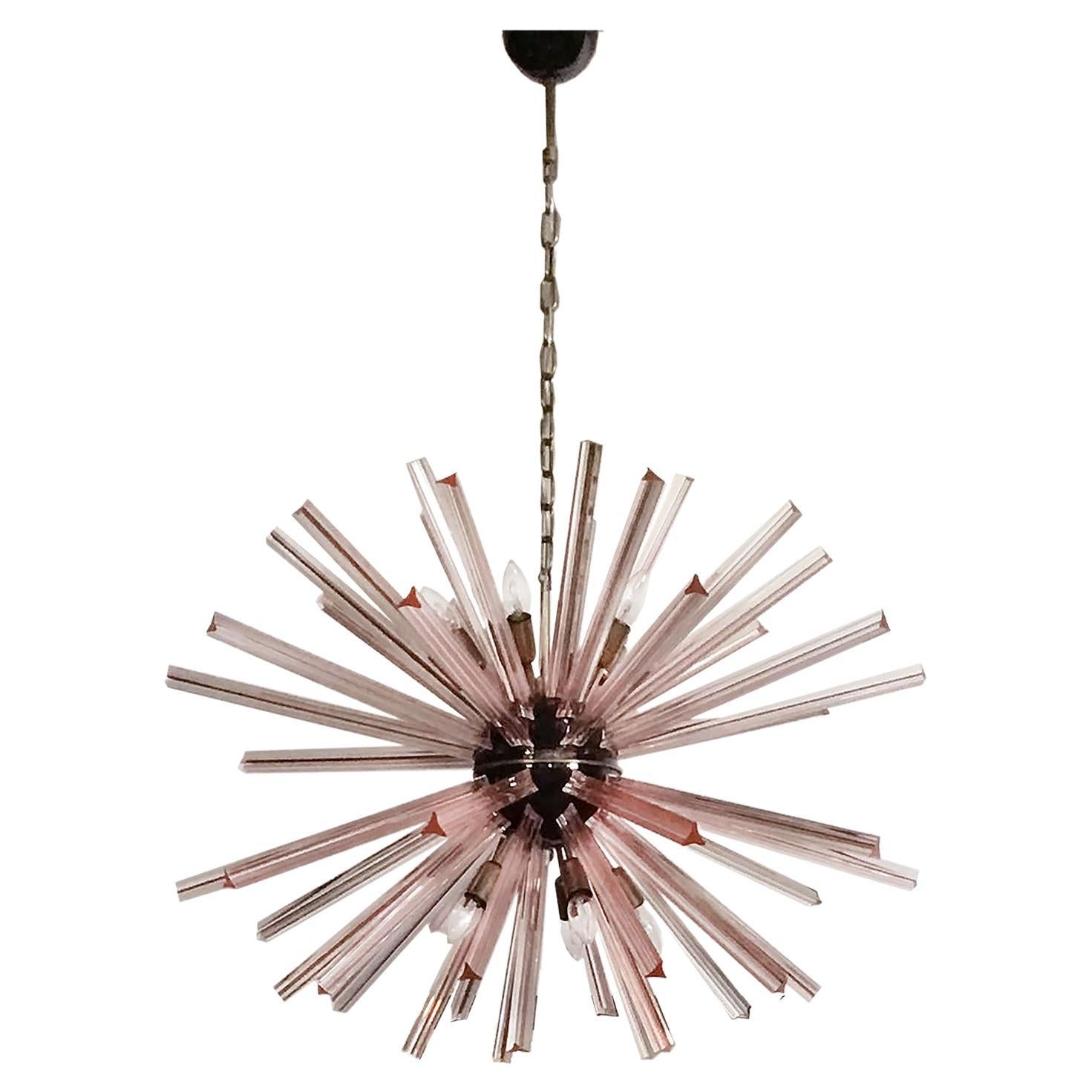 Pair Sputnik chandeliers surrounding 50 pink glass 'triedri' prisms radiating from a center black metal nucleus. Brass lamp holder. Period: late XX century
Dimensions: 51,20 inches (130 cm) height with chain; 27,55 inches (70 cm) height without