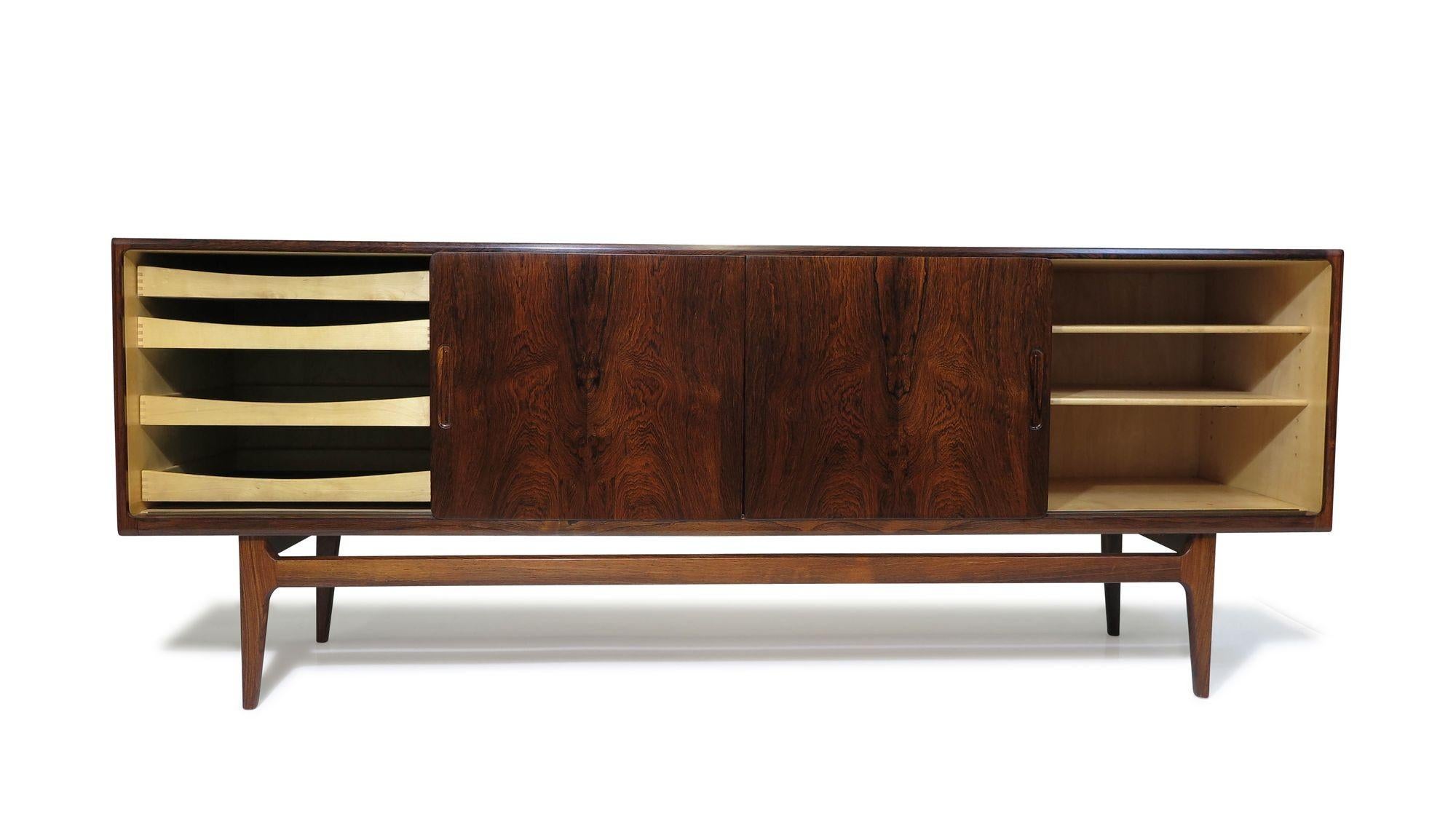 This Danish Credenza, designed and handcrafted in Denmark, 1952, is expertly handcrafted from Brazilian rosewood, showcasing exquisite joinery and the timeless sophistication of Danish furniture design. Its four sliding doors featuring book-matched
