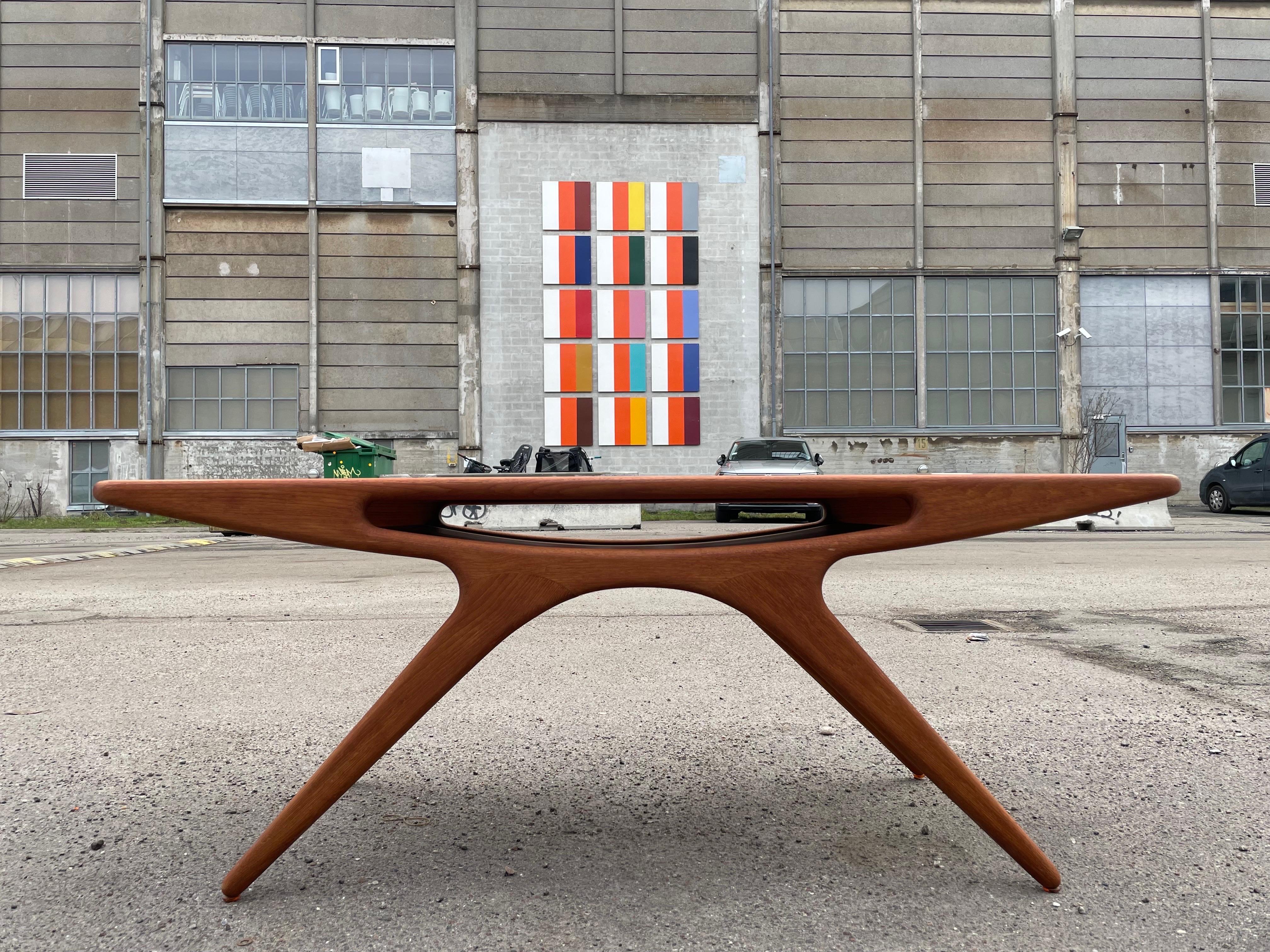Johannes Andersen was a master of Mid-Century Modern design, and his smile coffee table is a rare and highly collectible piece that perfectly showcases his unique talent. With its sleek teak body and center pocket shelf, this table is not only