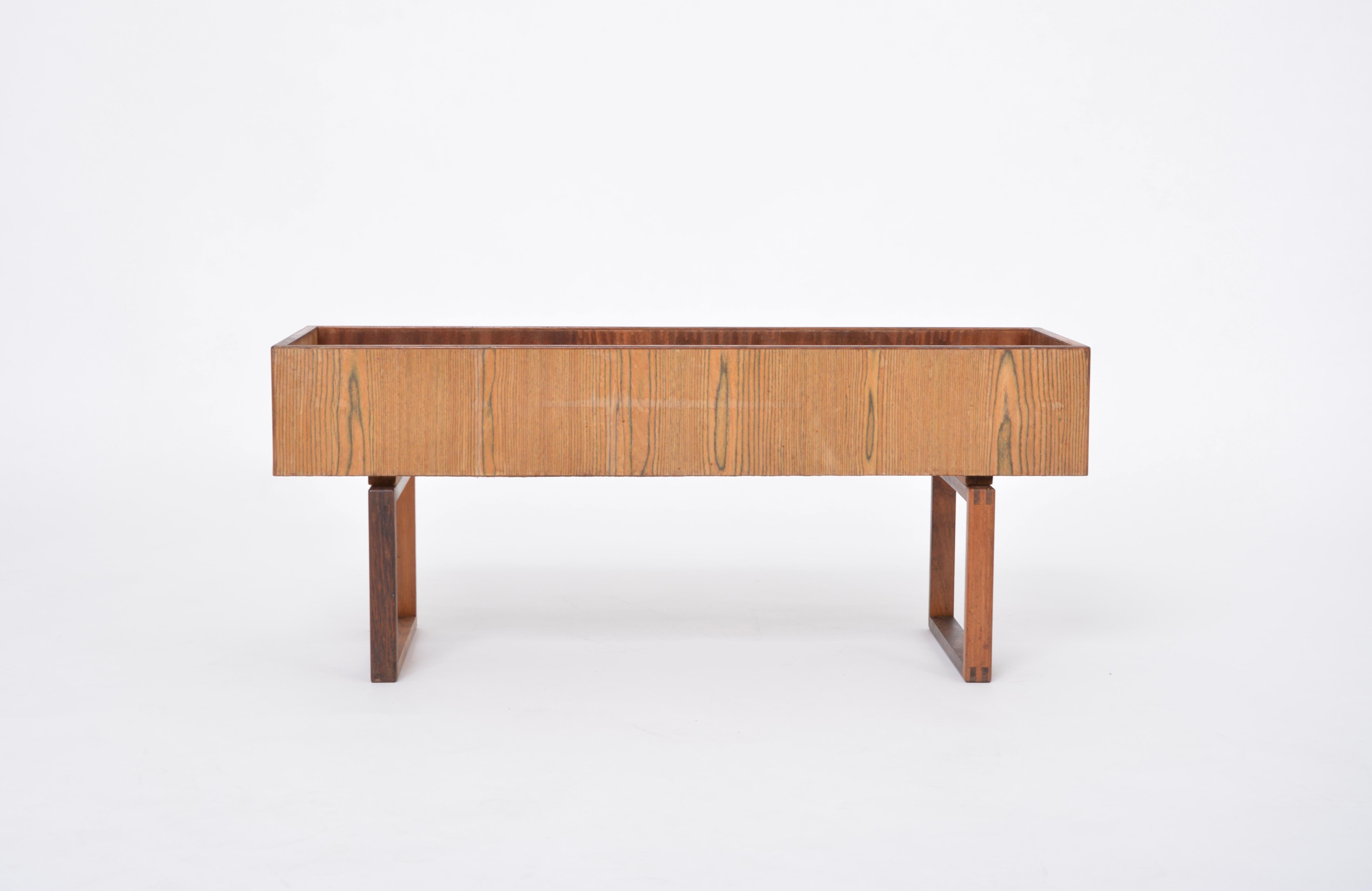 This indoor planter / flower box was produced in the 1960s in Denmark. Beautifully designed with a very graphic and minimal look, the planter stands on two square shaped legs. The flower box is made of teak.  Age realated normal traces of use. The