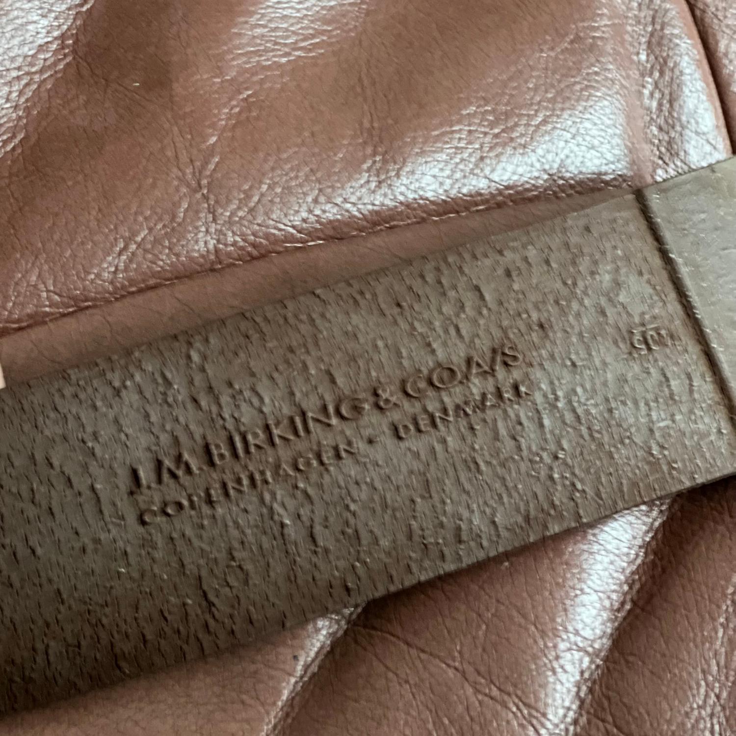 Fauteuil moderne danois de J.M. A&M, magnifiquement conservé. Birks & Co, fabriqué à Copenhague et portant l'étiquette originale du fabricant. Le cadre présente une construction sculpturale en bois courbé, finie dans une teinte acajou profond,