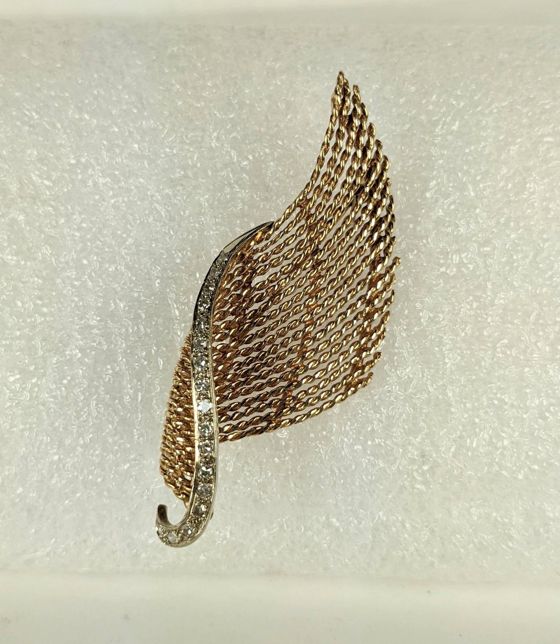 Elegant Diamond and Gold Wave Brooch from the 1960's. A line of bright diamonds lines the edge of this handmade 14k gold brooch. Hand twisted wires are used to give texture to the dimensional wave which can be worn in many different directions. 2.5