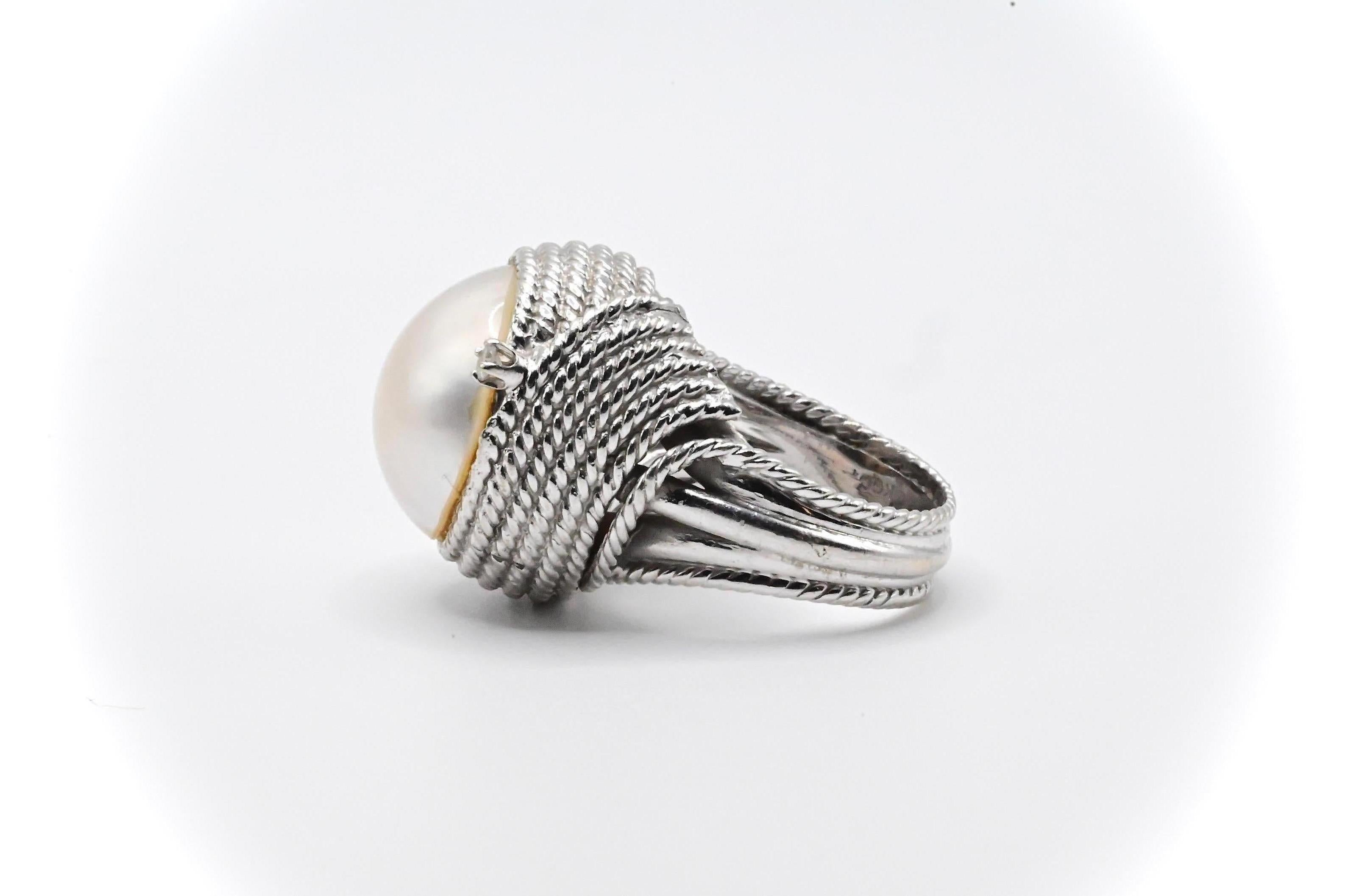 This is a stunning 14k white gold cocktail ring with an eye-catching pearl in the middle, and a simplistic diamond embellishment on both sides. It’s a size 7 ring that’s in good condition with some cosmetic wear, and weighs approximately 17 grams.