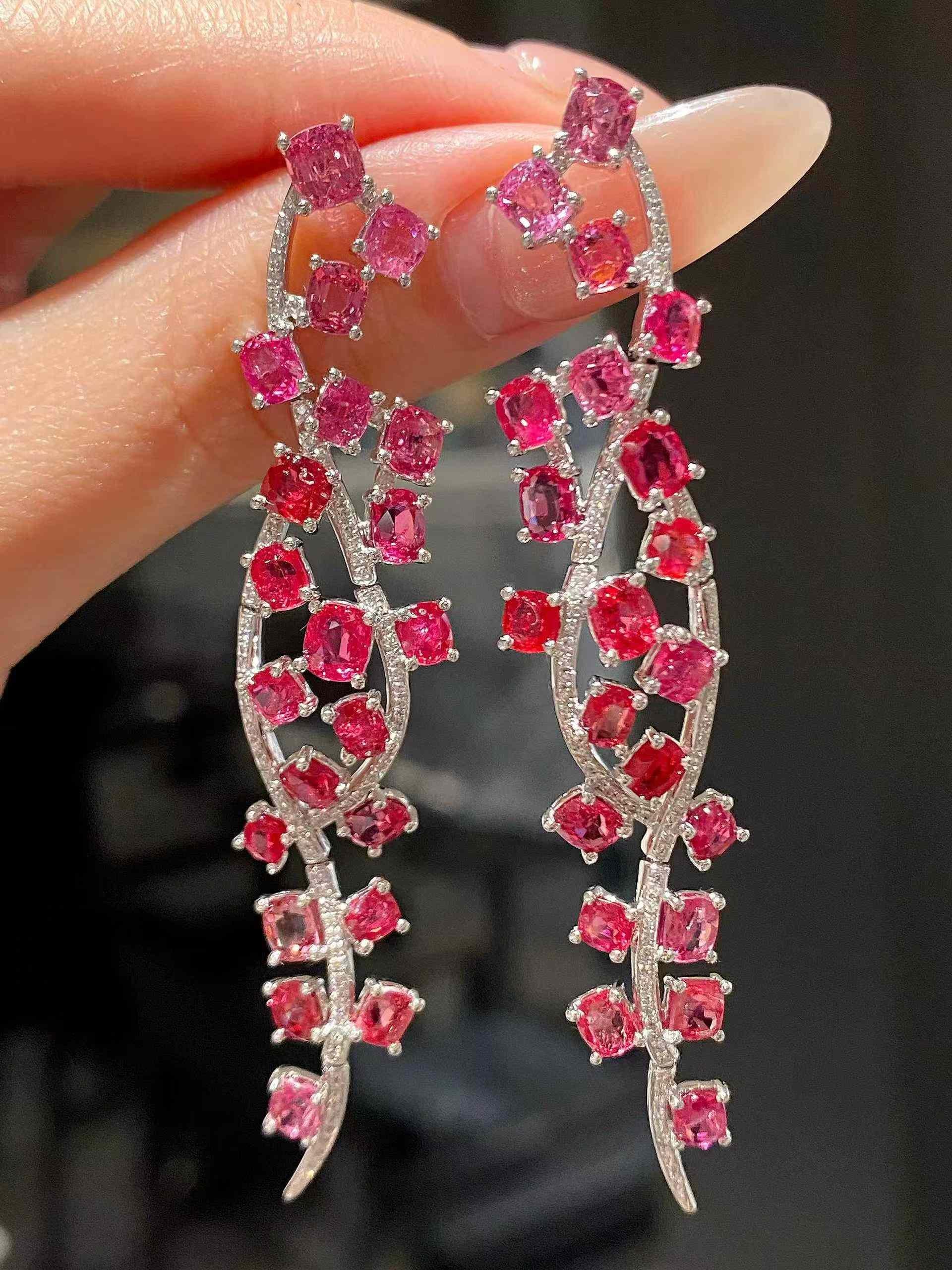 Questi splendidi orecchini a goccia in oro bianco 18 carati presentano un'affascinante coppia di vibranti gemme di spinello da 8 carati, splendidamente completate da 0,30 carati di diamanti scintillanti. Il colore ricco degli spinelli crea un