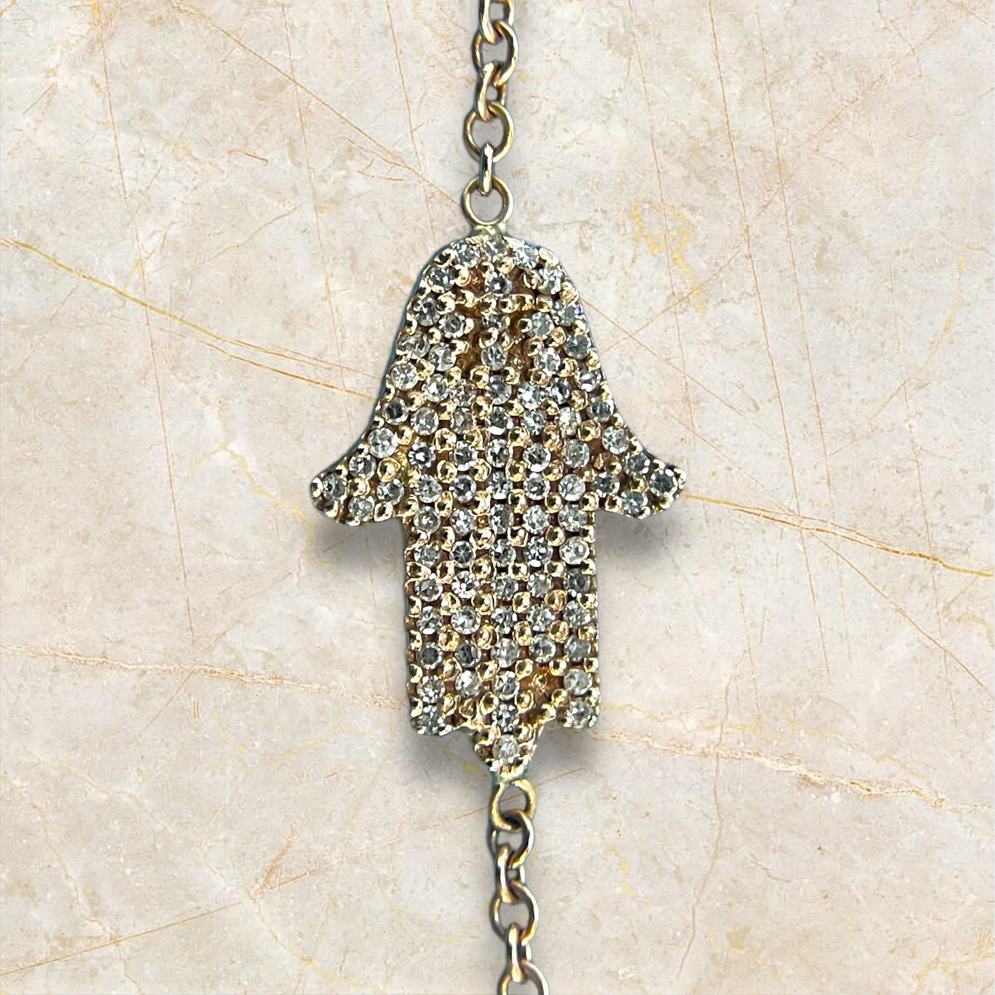 Embrace the protective charm of the Hamsa with this exquisite bracelet crafted in 14K rose gold. The delicate chain holds a stunning Hamsa pendant adorned with shimmering diamonds, symbolizing protection, blessings, and strength. The warm hue of