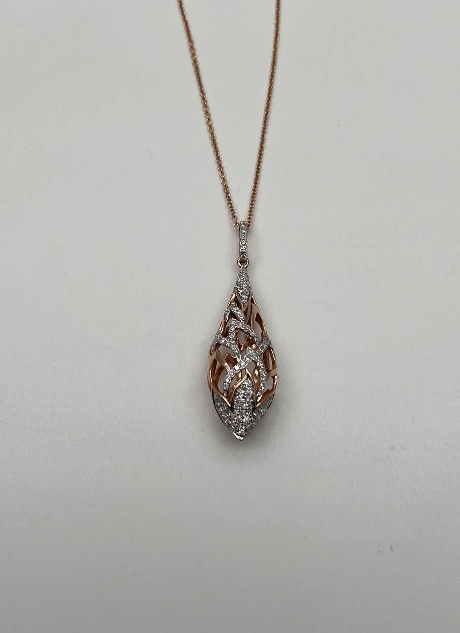 Questa intricata collana con ciondolo presenta un elaborato disegno a reticolo con una forma a goccia, ornata da diamanti scintillanti. La combinazione dei toni del rosa e del bianco aggiunge profondità ed eleganza al pezzo. Il ciondolo è sospeso a