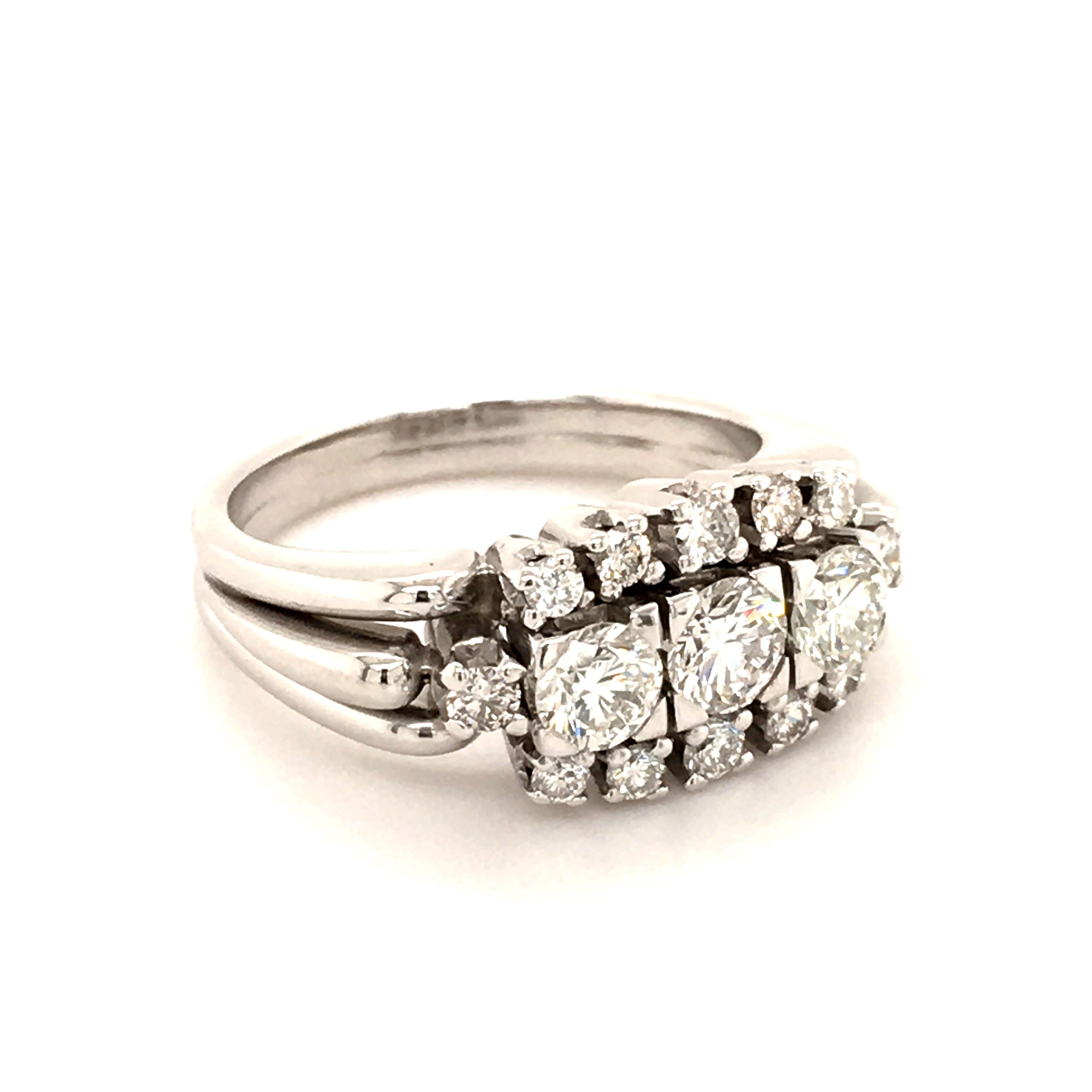 Elegant diamond ring in 18 Karat white gold designed as a three stone ring in the middle, flanked by two smaller round diamonds. The three main round brilliant-cut diamonds have a total weight of approximate 0.70 ct and are of G/H-vs quality. Long