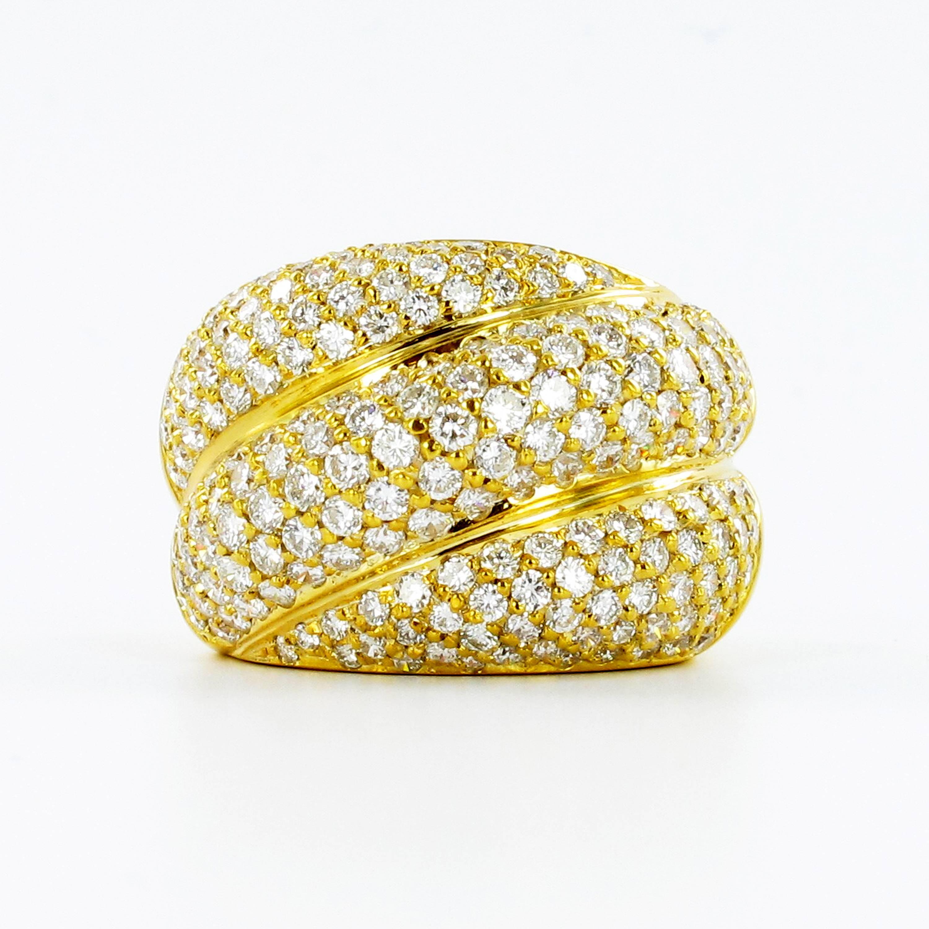 Classic diamond band ring in yellow gold 750. Pavé set with 190 brilliant cut diamonds totaling approximate 2.90 ct. The diamonds are of G/H color and si clarity. Assay mark for gold 750 and maker's mark. 

Matching pair of earclips on stock.

Ring