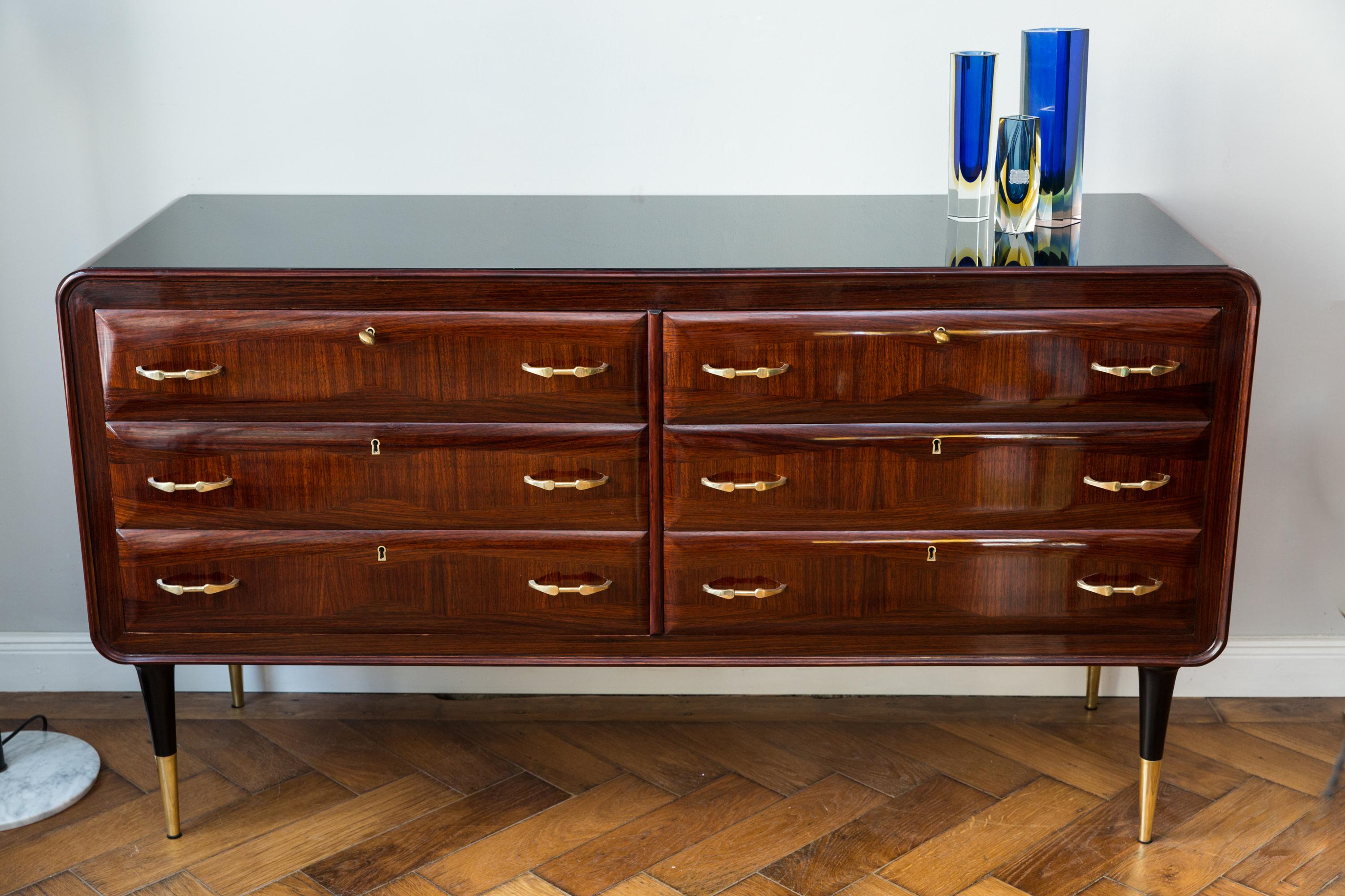Very elegant dresser, Italy, Santos rosewood, conical feet in brass and black polished shellac, six large drawers with solid brass handles, each lockable, brass key with lentil head, respective drawer fronts with very elegant running veneer