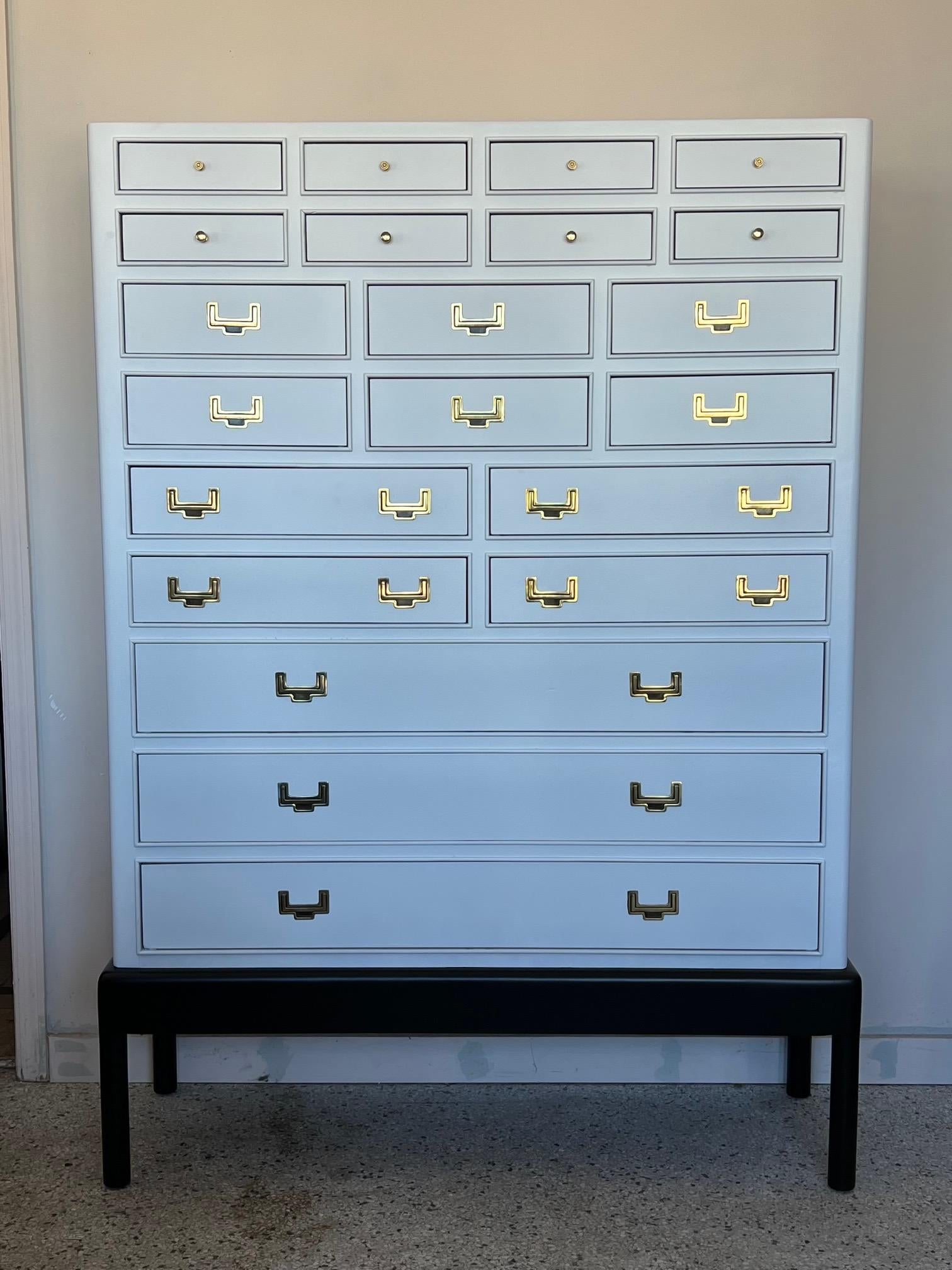 Elegant and unusual twenty one drawer cabinet. Polished brass hardware. Impressive scale at 65.5