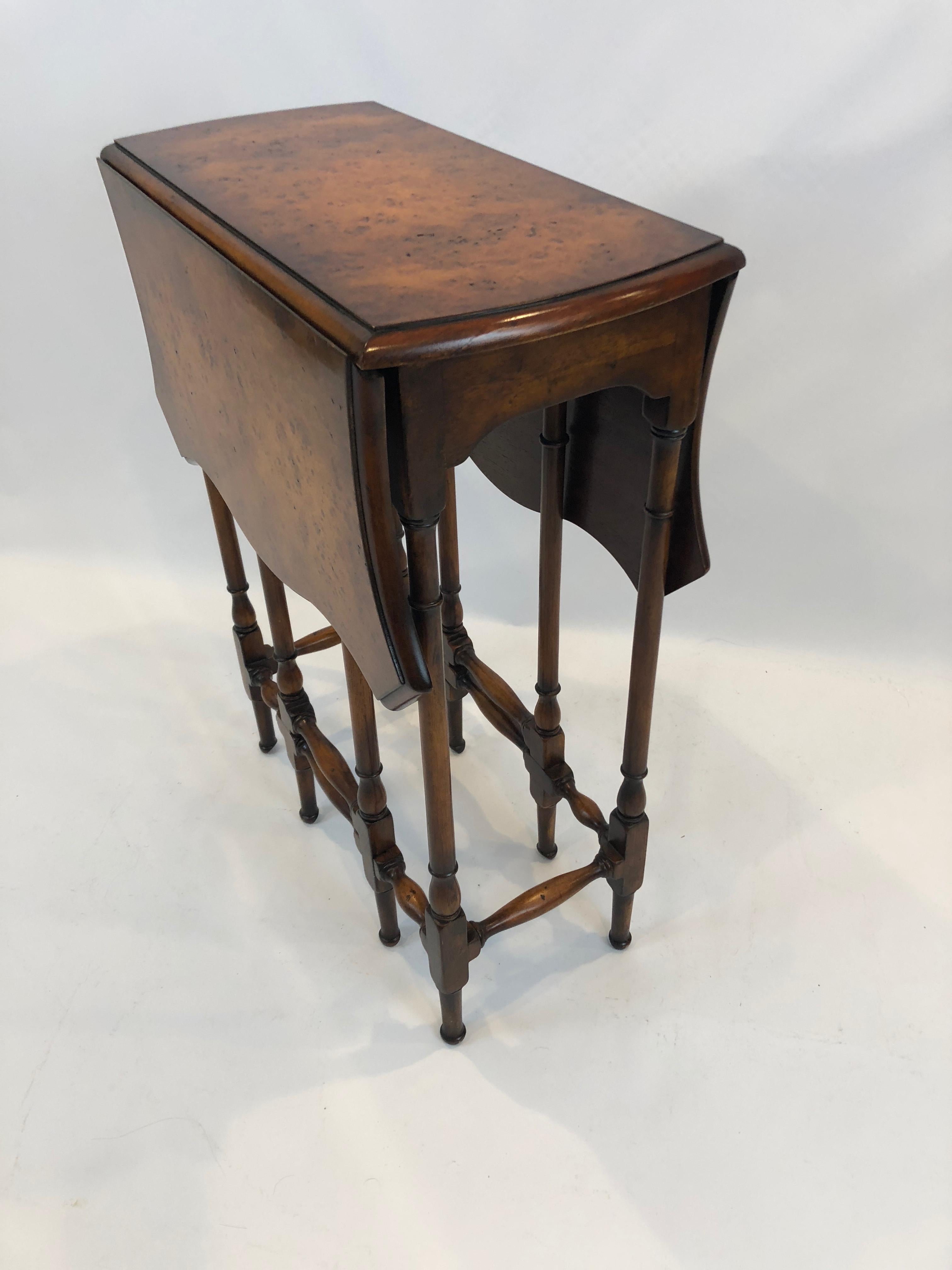 A gorgeous burl wood dropleaf gateleg side table that is a narrow 11.5 inches wide when closed but opens much larger to a lovely scalloped shape. The legs are especially pretty as is the grain of the wood.