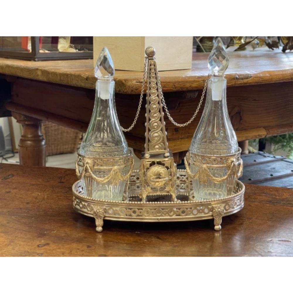 Elegant and exceptional early 19th Century marked Dutch silver and crystal oil and vinegar cruet stand. The center handle in the shape of an obelisk. The cruets rest in swag fittings, and stand on a galleried oval base finely engraved, floral feet,