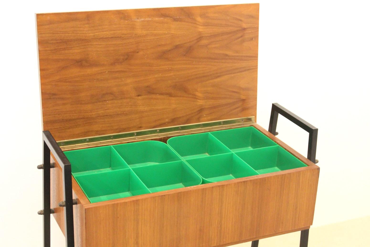 Gorgeous original Dutch Collectors Cabinet and Sewing Table in Teak. The Cabinet features beautiful wood grain with black metal legs on wheels. It offers good storage, with 8 different boxes. The Cabinet is in very good original vintage condition