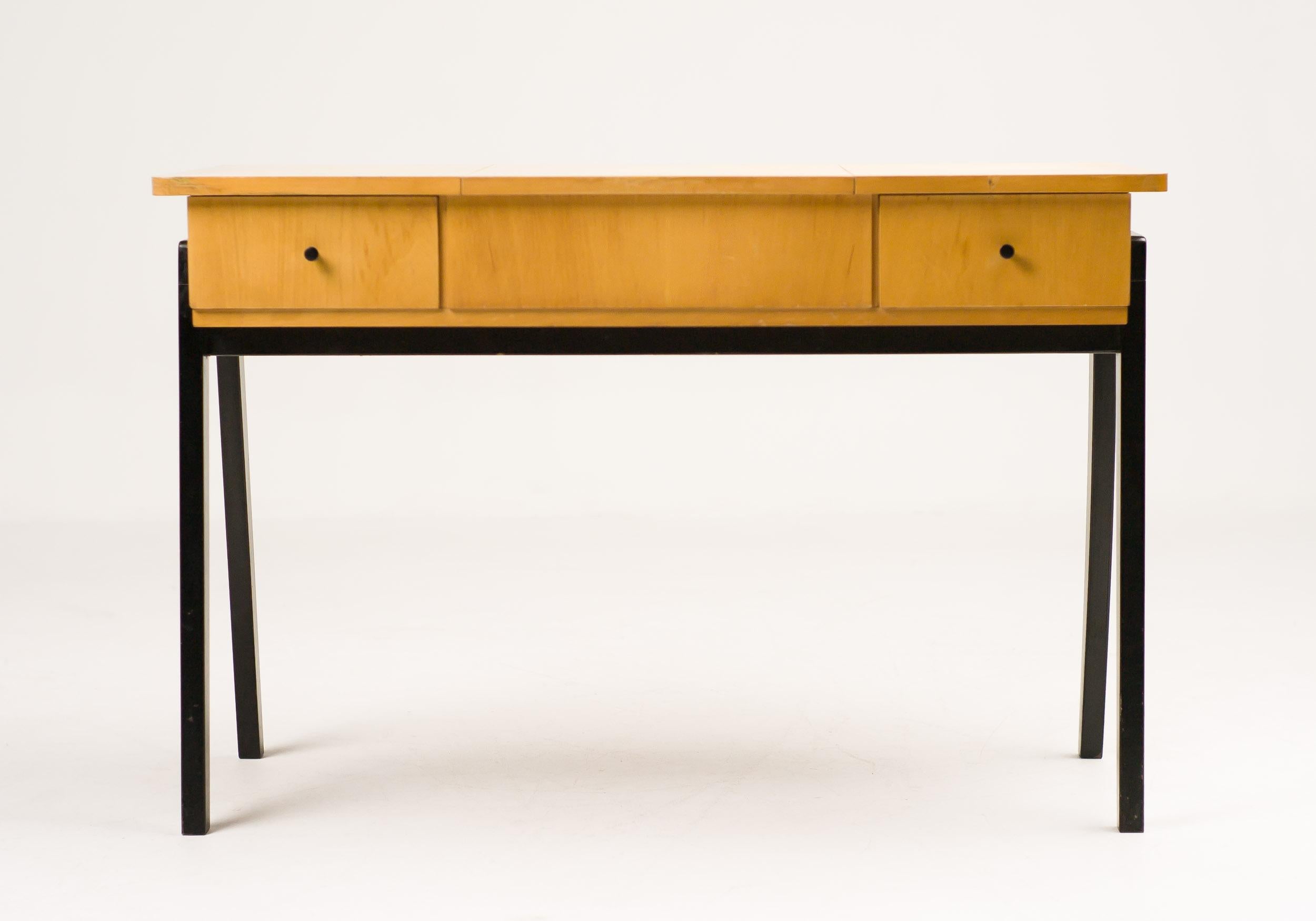 Este elegante tocador holandés de los años 50 ejemplifica el refinamiento de mediados de siglo con sus líneas limpias, materiales cálidos y cuidada artesanía. Ejecutada en abedul bellamente veteado, la pieza irradia un suave tono dorado que aporta