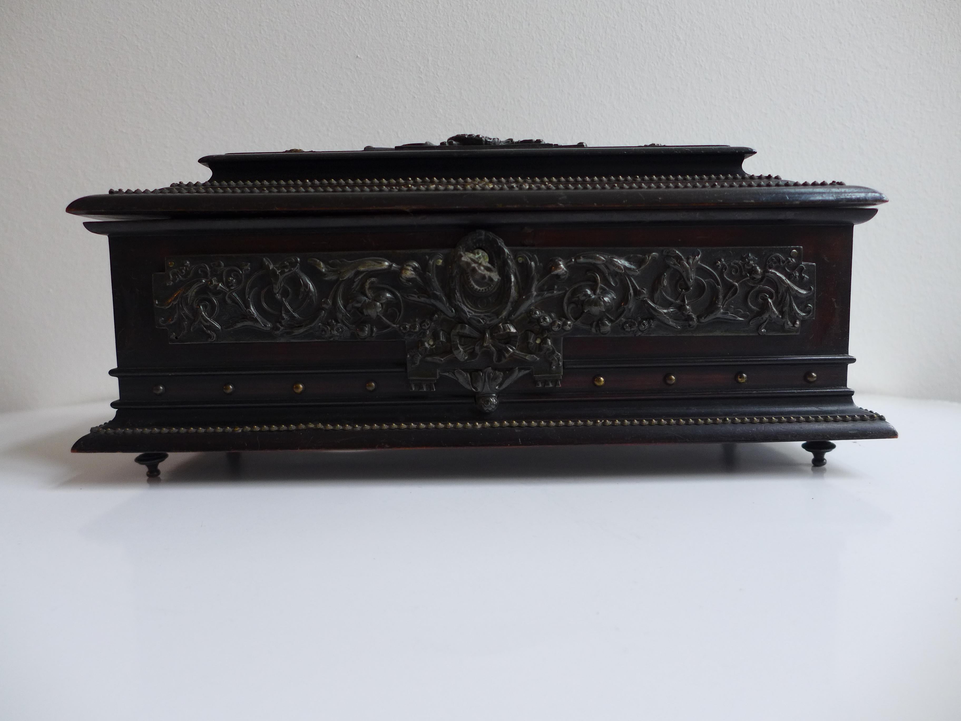 Elegant ebony chest with silvered brass fittings, complete with its original key. The interior is lined in rich velvet and finished with classic Chesterfield tufted upholstery, adding a touch of luxurious craftsmanship. A refined decorative piece