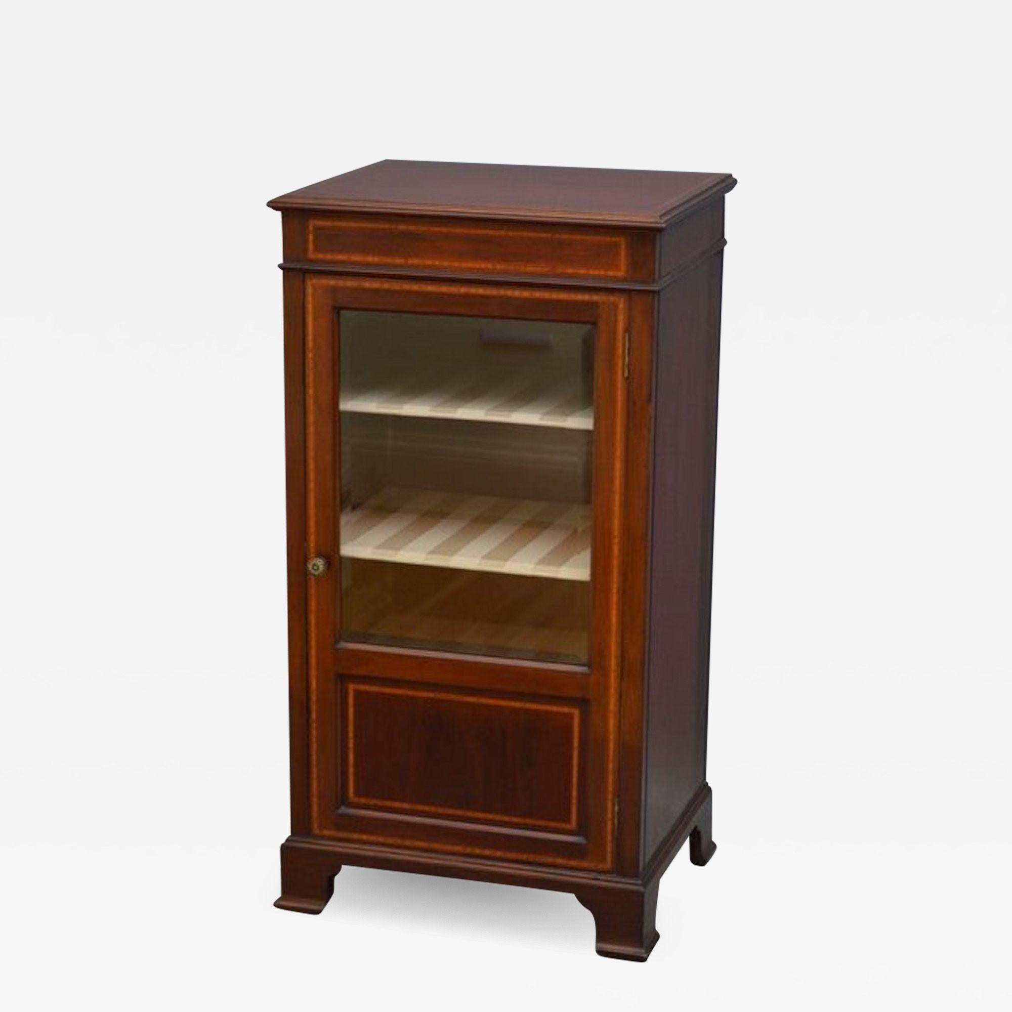 Sn3655 Vetrina in mogano di epoca edoardiana, con piano in legno satinato a fasce incrociate e modanate e porta intarsiata e vetrata con maniglia originale in ottone, che racchiude 3 ripiani rimovibili, sollevata su piedini a staffa sagomati e