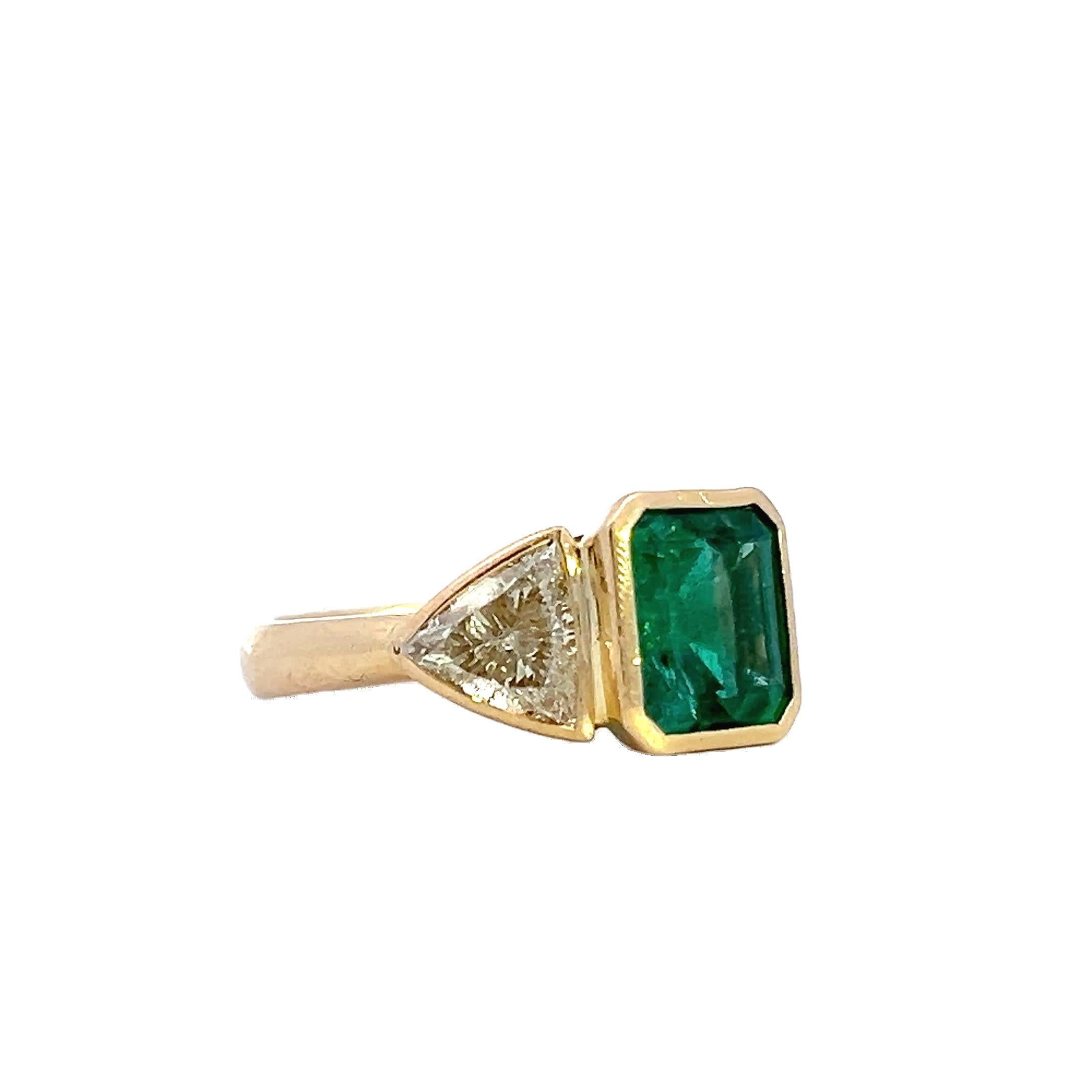 This stunning ring features a captivating emerald centerpiece flanked by two sparkling diamonds. The combination of the vibrant green gemstone with the brilliance of the diamonds creates an exquisite piece that exudes elegance and sophistication.