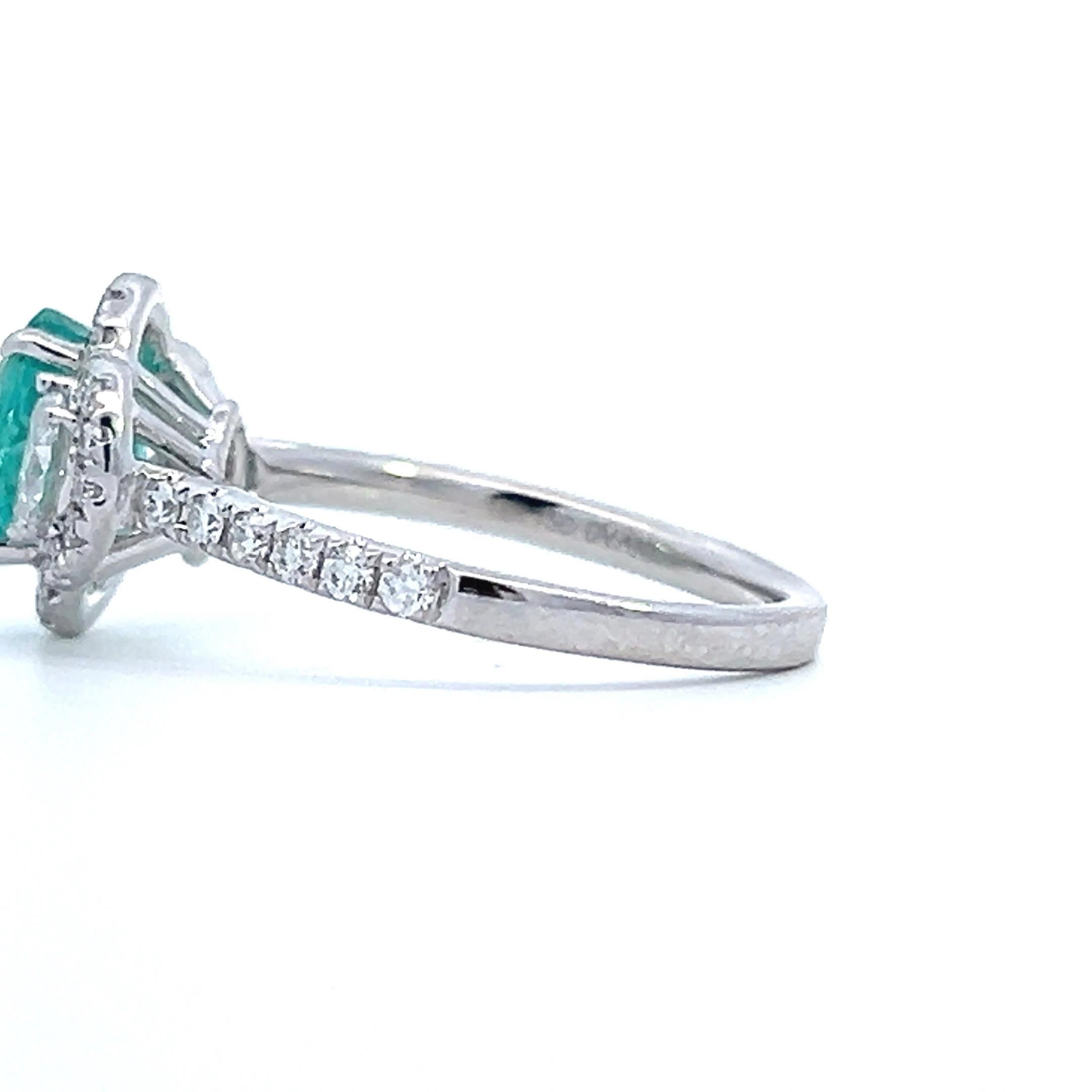 Dieser exquisite Ring zeigt einen atemberaubenden Smaragd in der Mitte, umgeben von einem Heiligenschein aus funkelnden Diamanten. Das filigrane Design und die brillanten Edelsteine machen sie zur perfekten Wahl für alle, die Eleganz und Raffinesse