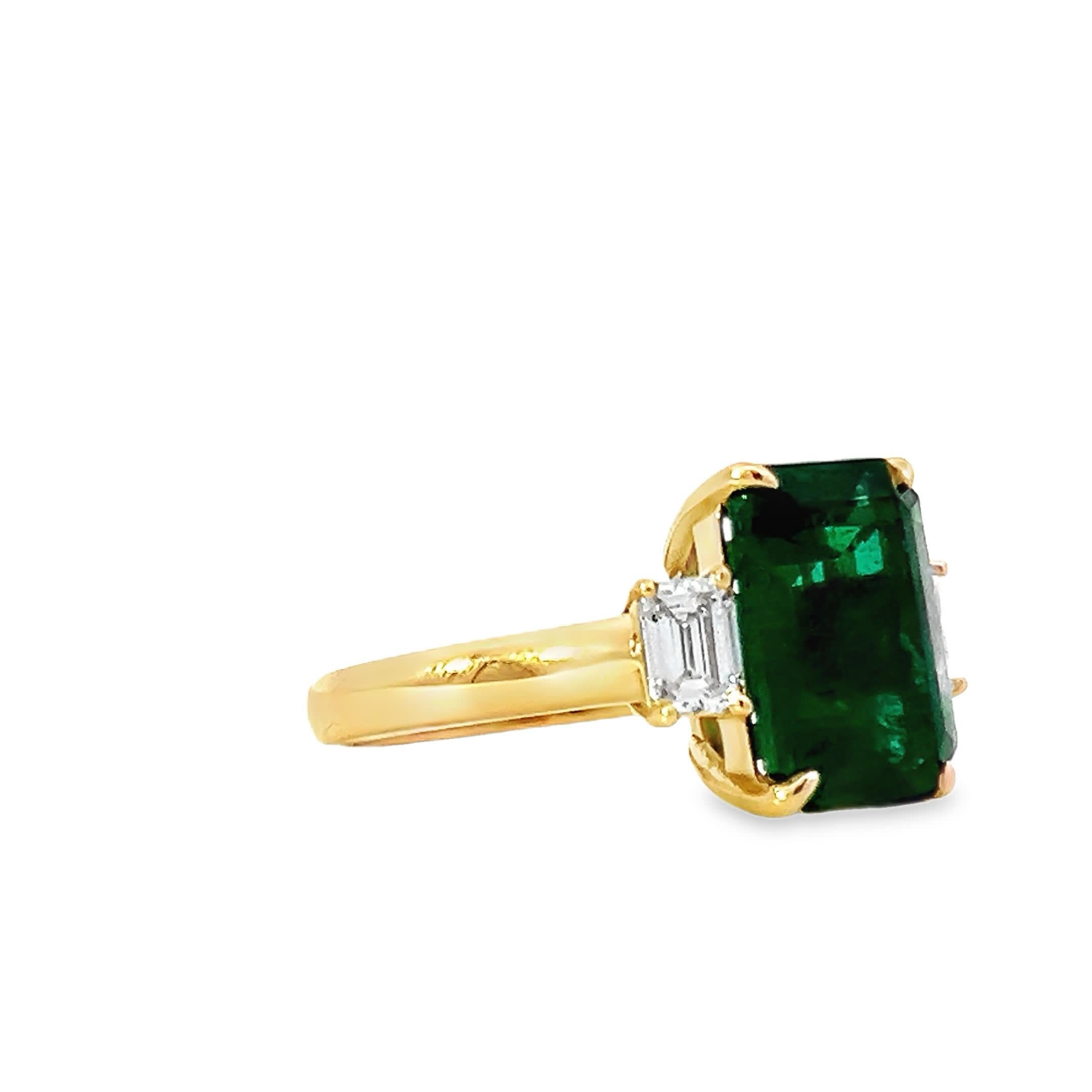 Dieser atemberaubende Ring zeigt einen großen, rechteckigen Smaragd, der von zwei schillernden Diamanten flankiert wird. Der satte Grünton des Smaragds ergänzt sich perfekt mit der funkelnden Brillanz der Diamanten und schafft ein exquisites