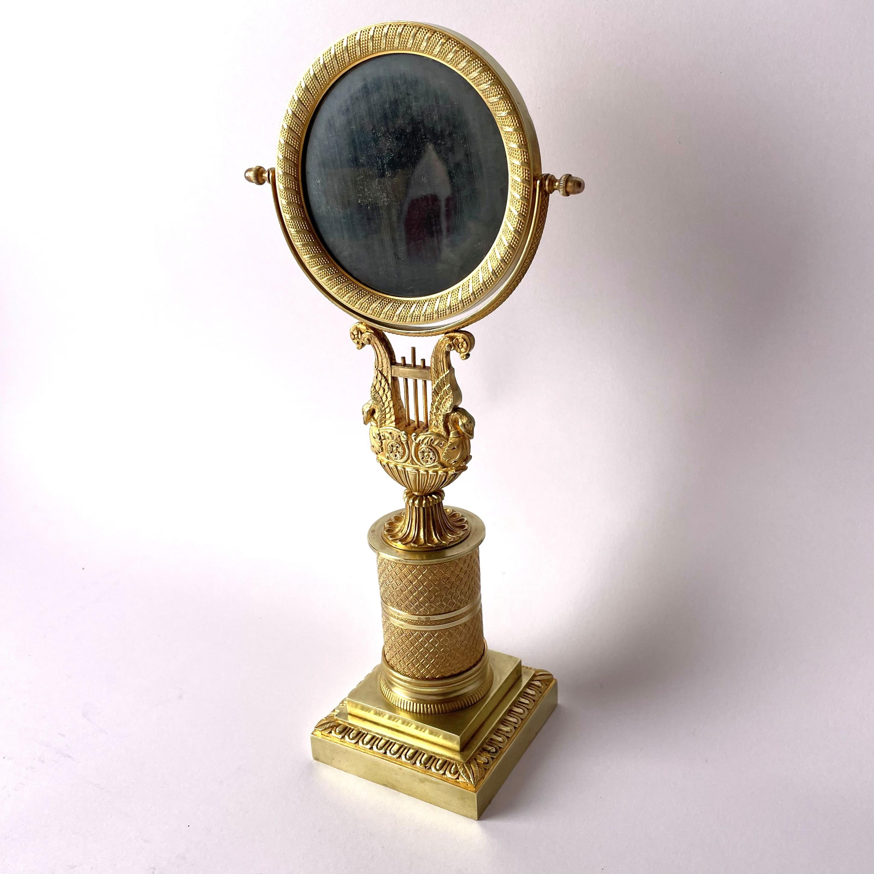 Eleganter und seltener Empire-Tischspiegel aus vergoldeter Bronze. Sehr gute Qualität. Hergestellt in Frankreich um 1820, mit originalem Spiegelglas mit Patina.

Alters- und gebrauchsbedingte Abnutzungserscheinungen.