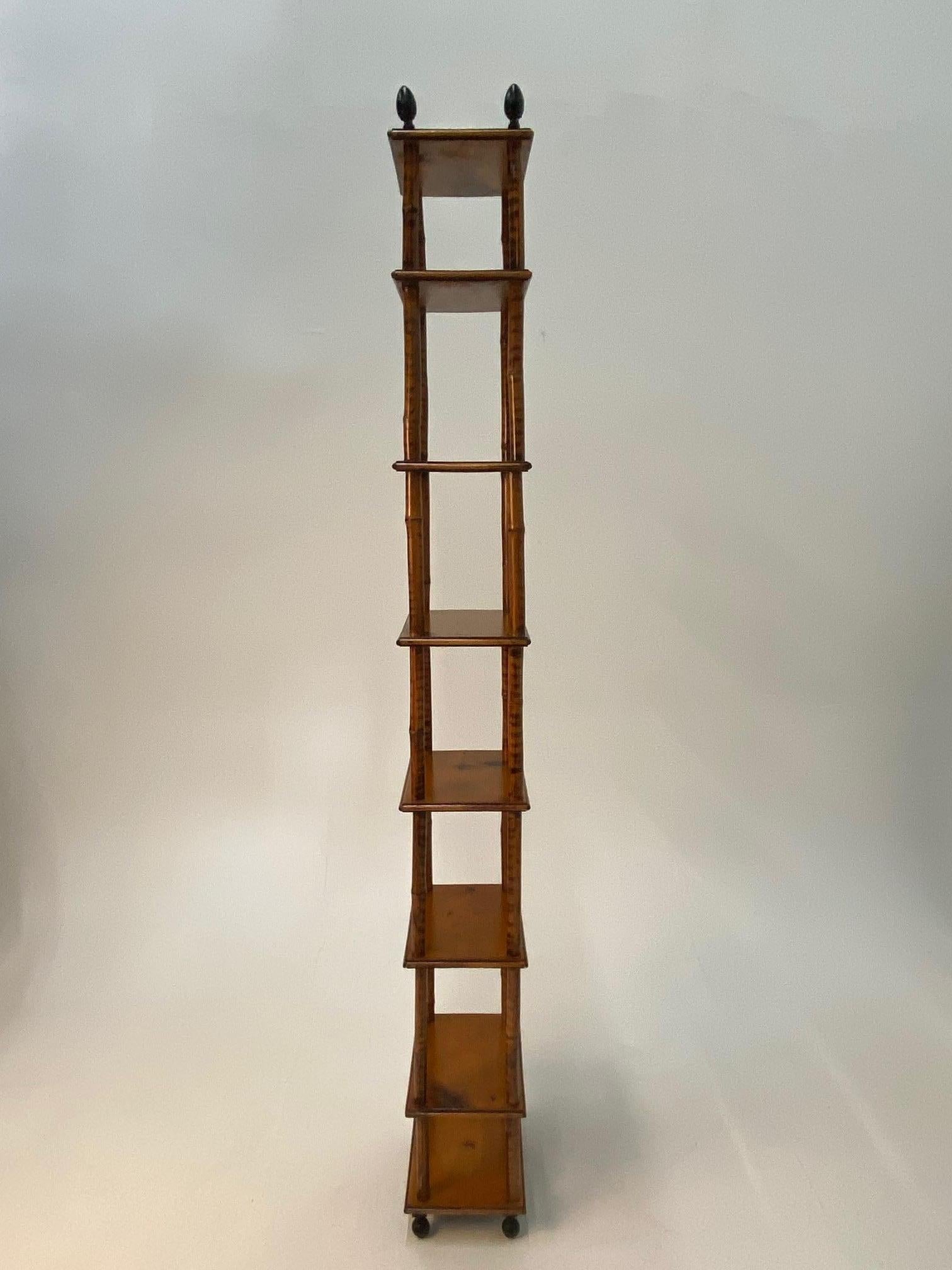An elegant very tall antique etagere constructed of bamboo rods having 8 wooden shelves with decorative iron finials at the top and iron ball feet. Top and bottom shelves are 8