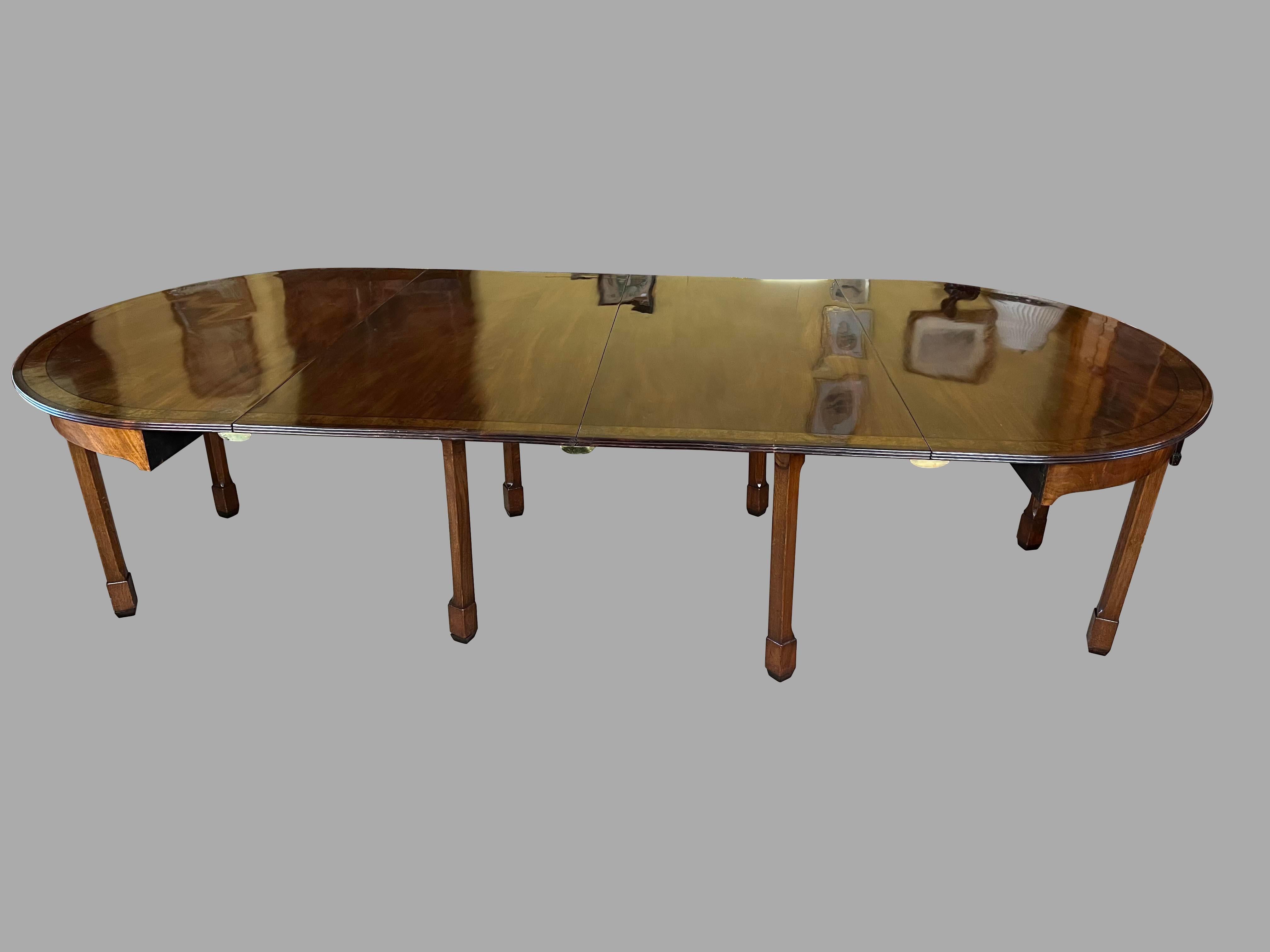 A fine English inlaid mahogany dining table, the well-figured mahogany top with lovely burl walnut crossbanding. supported on square legs ending in block feet. The table can be used in multiple configurations: with no leaves  measuring 58