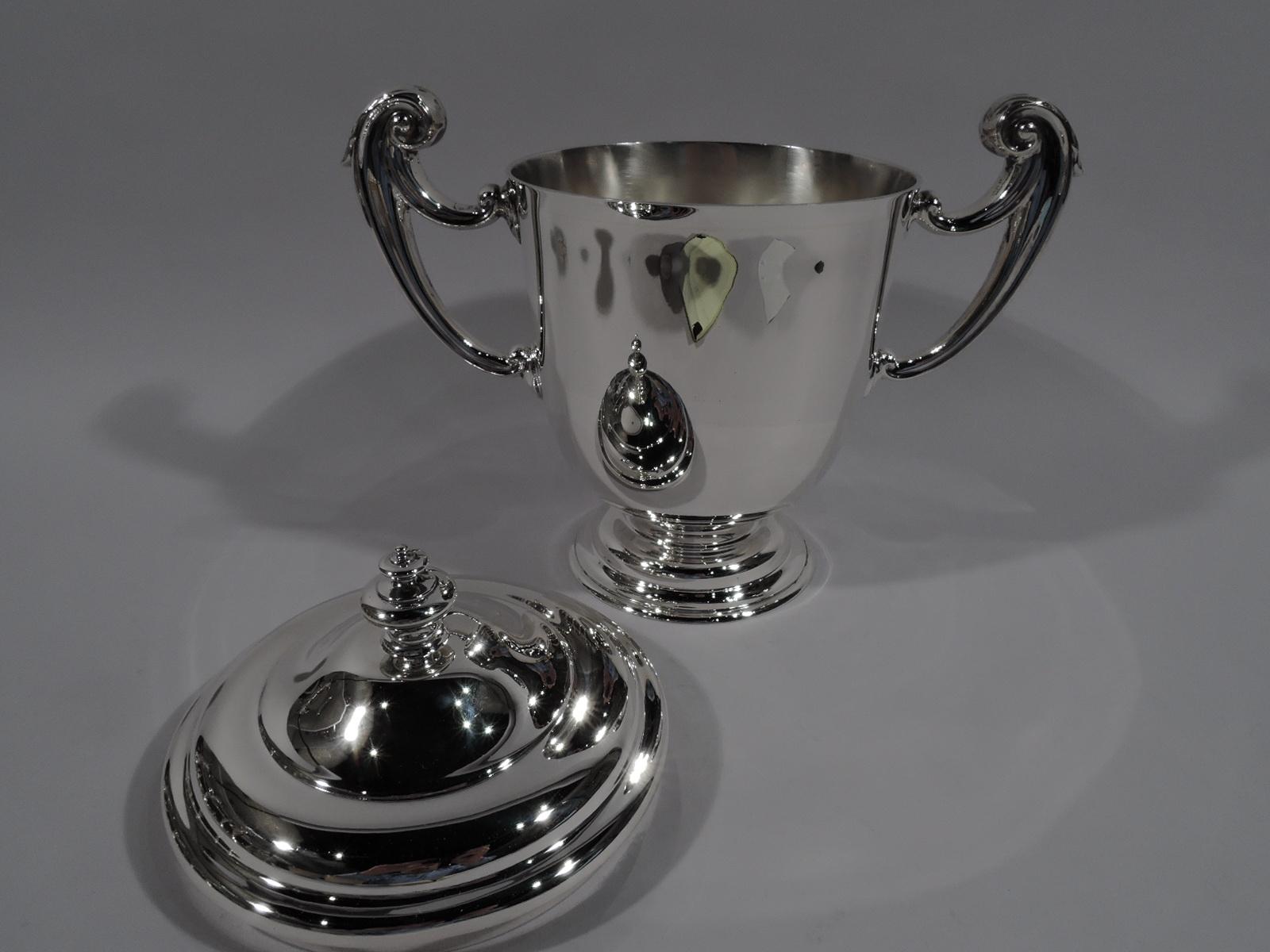 George V sterling silver Classical covered urn. Made by Lionel Alfred Crichton in London in 1913. Traditional urn with flying leaf-capped side handles and stepped foot. Cover domed with ornamental finial. Nice heft. Awaits engraving. Fully marked.