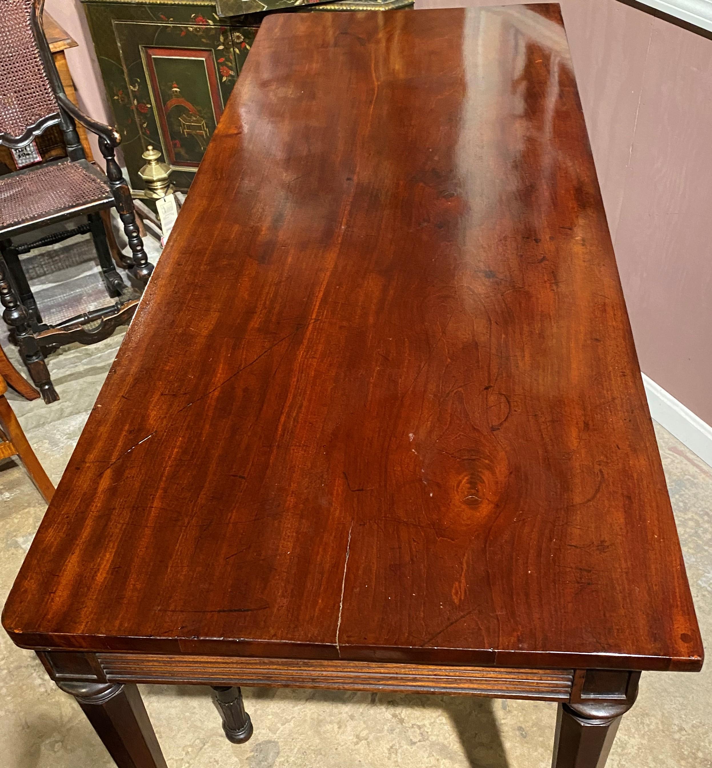 An elegant George III mahogany rectangular serving table in the Adam Style, with horizontal reeded frieze and supported by six round straight legs, tapered with panels, terminating with acanthus decorated feet. Dates to the late 18th or early 19th