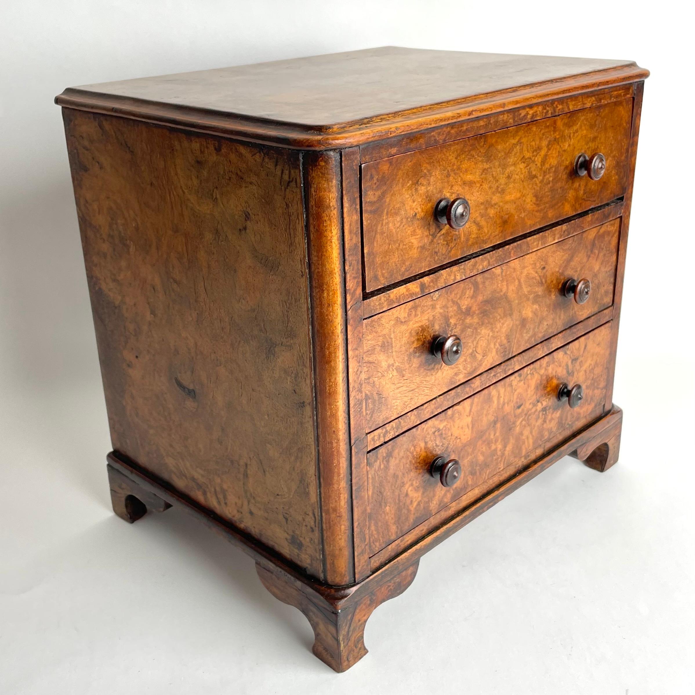 Elegant English miniature chest of drawers in walnut burl from Mid-19th Century. 

Perfect as a jewelry or collector’s box.

Wear consistent with age and use 